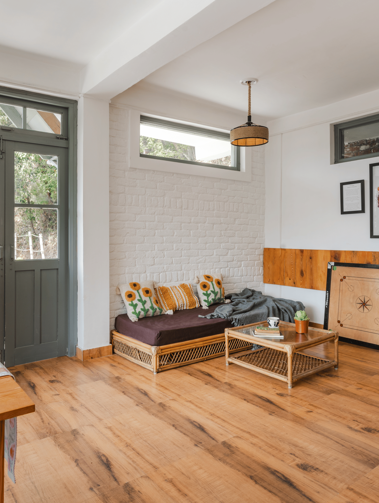An indoor living and dining area with wooden furniture and a bookshelf at Ziran Retreat.