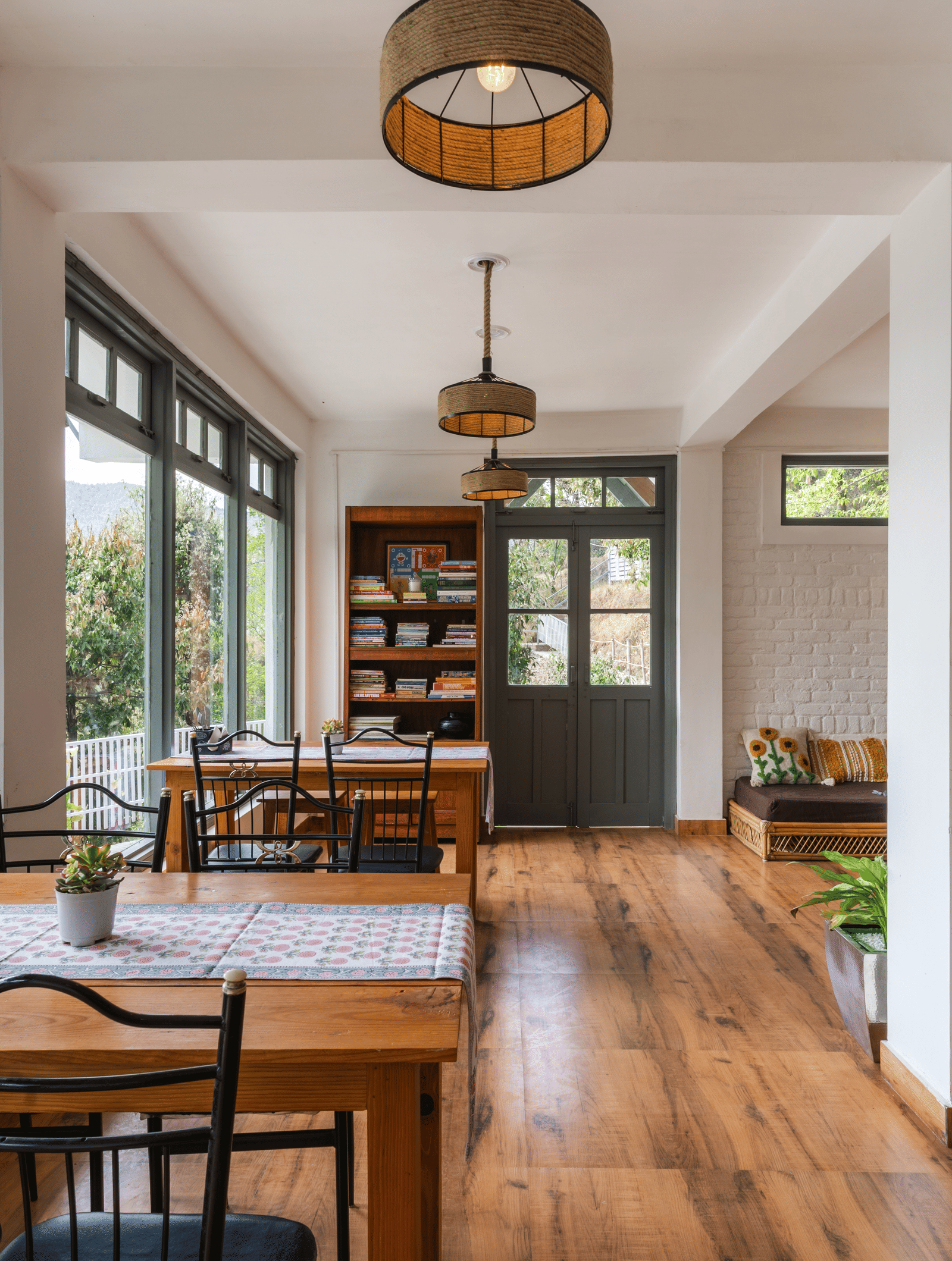 An indoor dining and living area with large windows at Ziran Retreat.