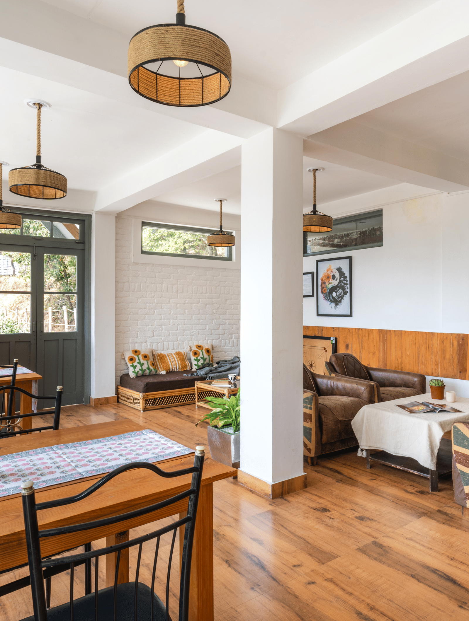 An indoor dining and living area with wooden floors and furniture at Ziran Retreat.