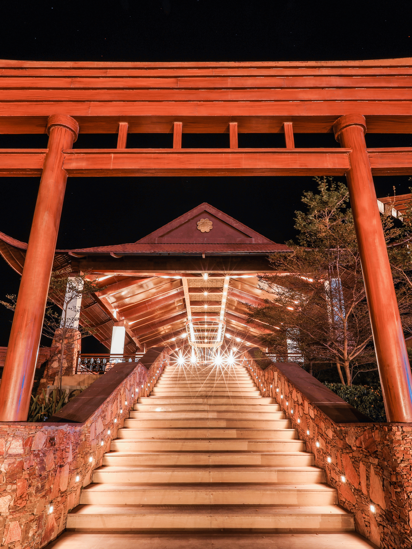 A staircase leading to a large gateway structure with trees on both sides at Ananta Spa and Resort, Jaipur