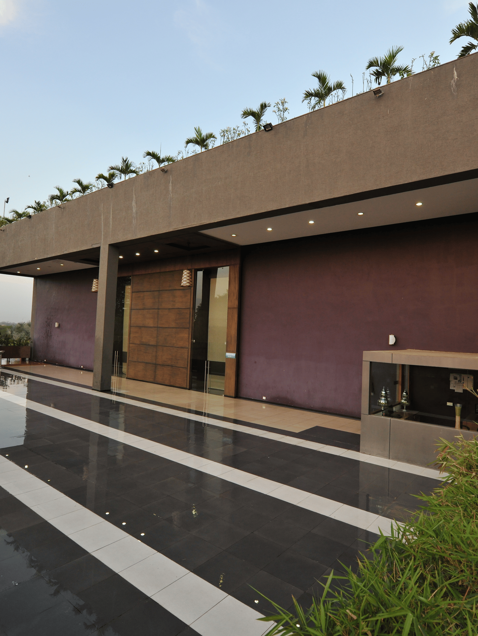 Exterior of a modern building with a sleek, minimalist design at Narayani Heights Hotel & Resorts, Ahmedabad.