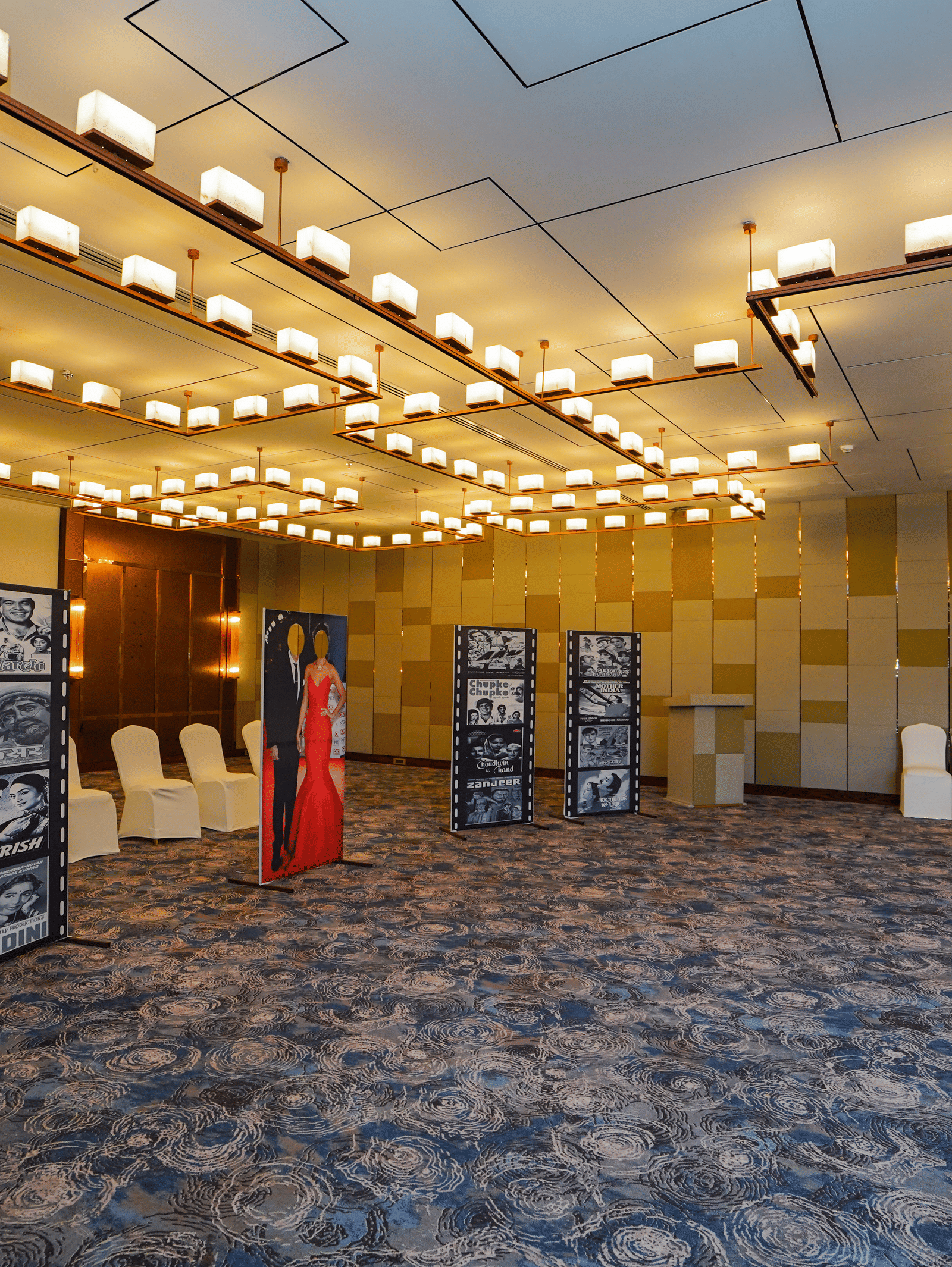 A wide-angle shot of an event space with rows of chairs and a few display boards, indicating a presentation or conference is about to begin.