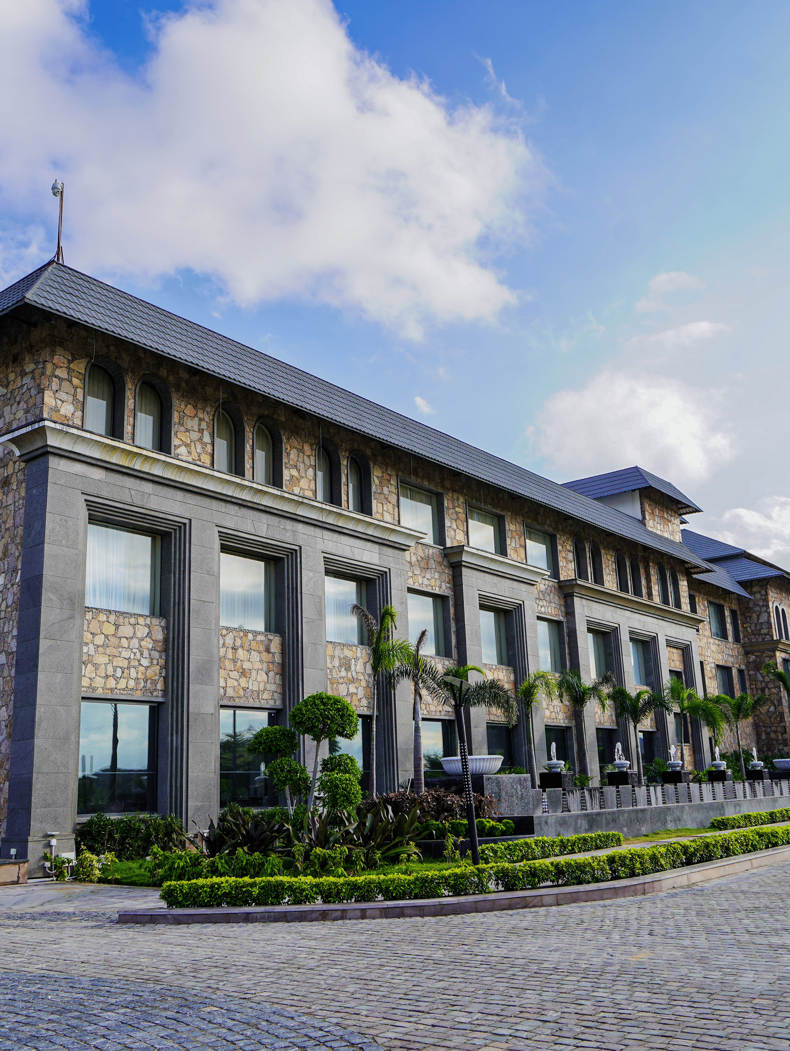 A low-angle shot of a multi-storey stone and glass building, which is the main part of the resort.