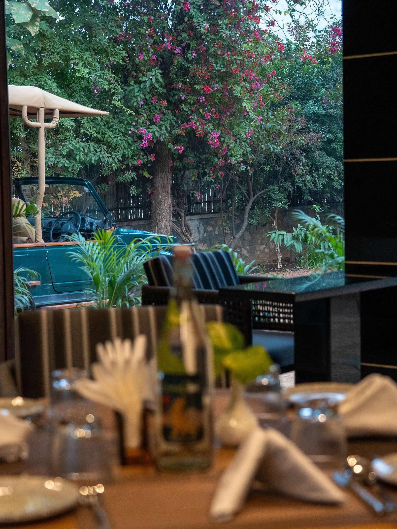 A beautifully set dining table with glasses and crockery at Aamaghati Jungle Retreat Ranthambore.