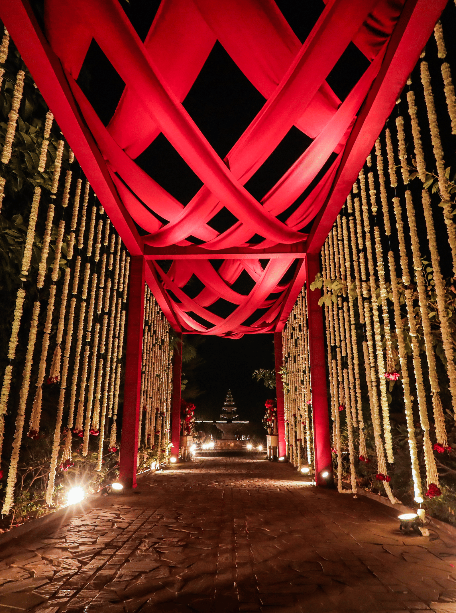 An entrance tunnel with a tall overhead structure and pathway lighting at Ananta Spa and Resort, Jaipur