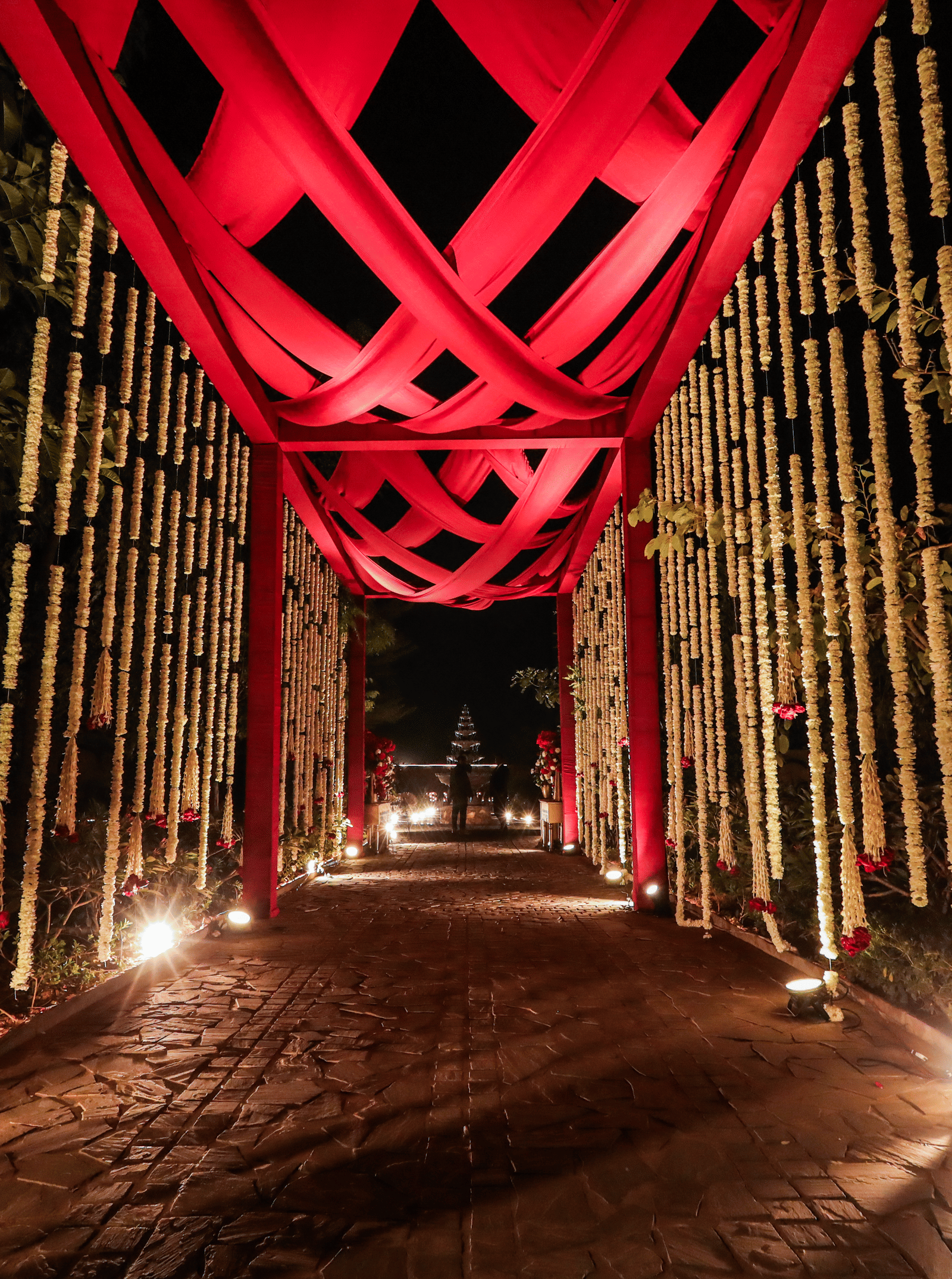 An entrance walkway with a tall overhead structure and lighting at Ananta Spa and Resort, Jaipur