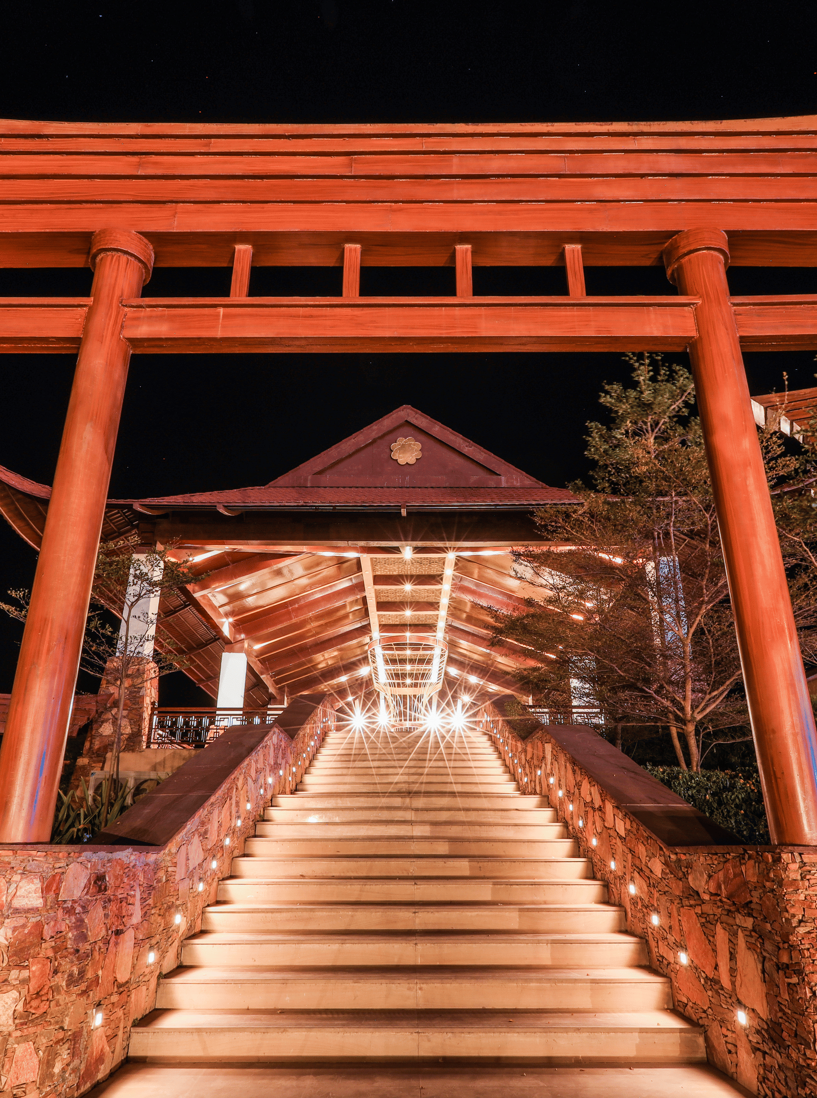 A staircase leading to a large gateway structure with trees on both sides at Ananta Spa and Resort, Jaipur