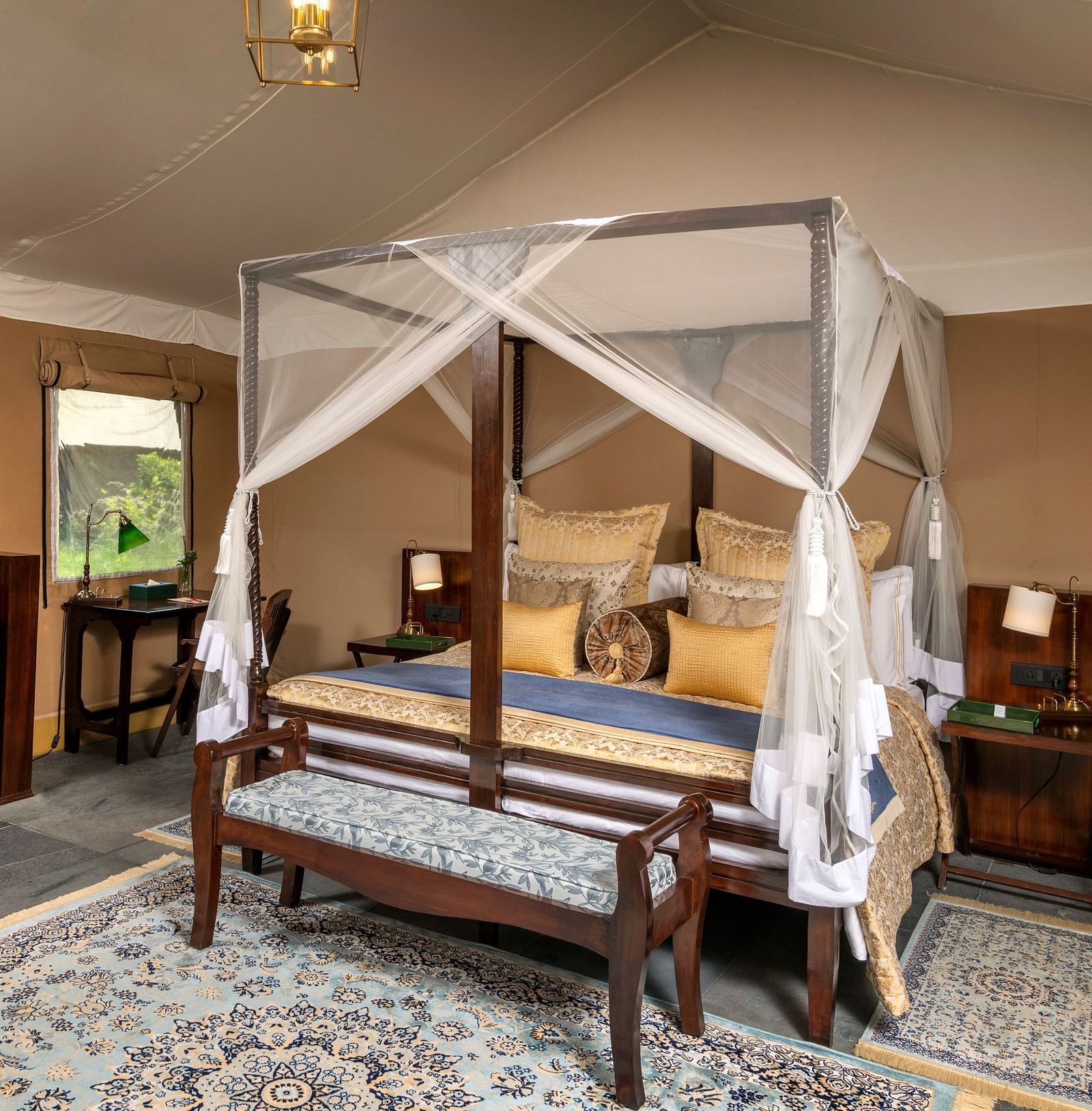 luxury king tents with a large bed on a wooden frame, a cosy sitting couch and amenities - Aalia Jungle Resort & Spa