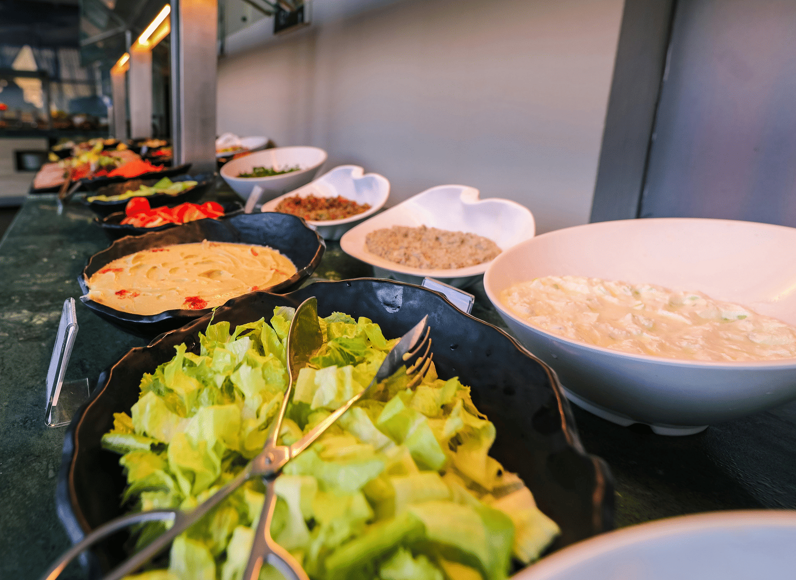 An indoor buffet set up with open bowls showcasing the variety of dishes.