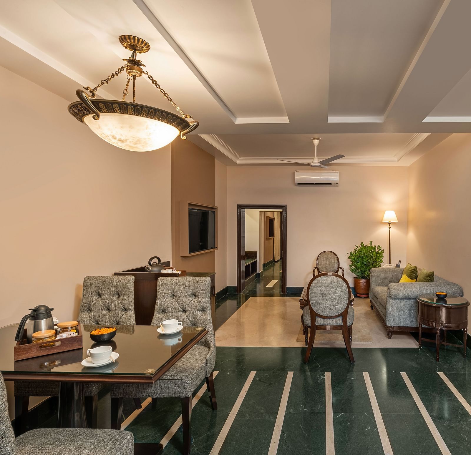 Maharaja Suite Living Room with a table set for dining and sofas for sitting - Ganga Lahari, Haridwar