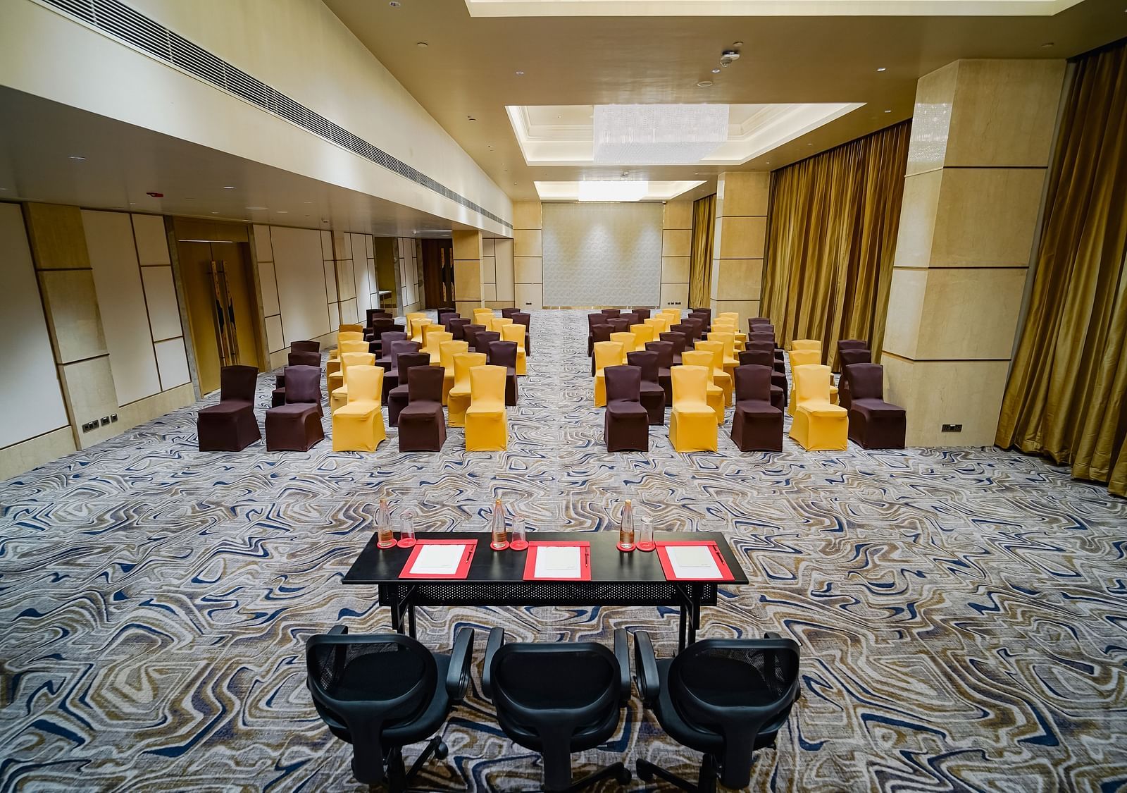 A formal meeting space with classroom-style seating, elegant lighting, and ample room for presentations