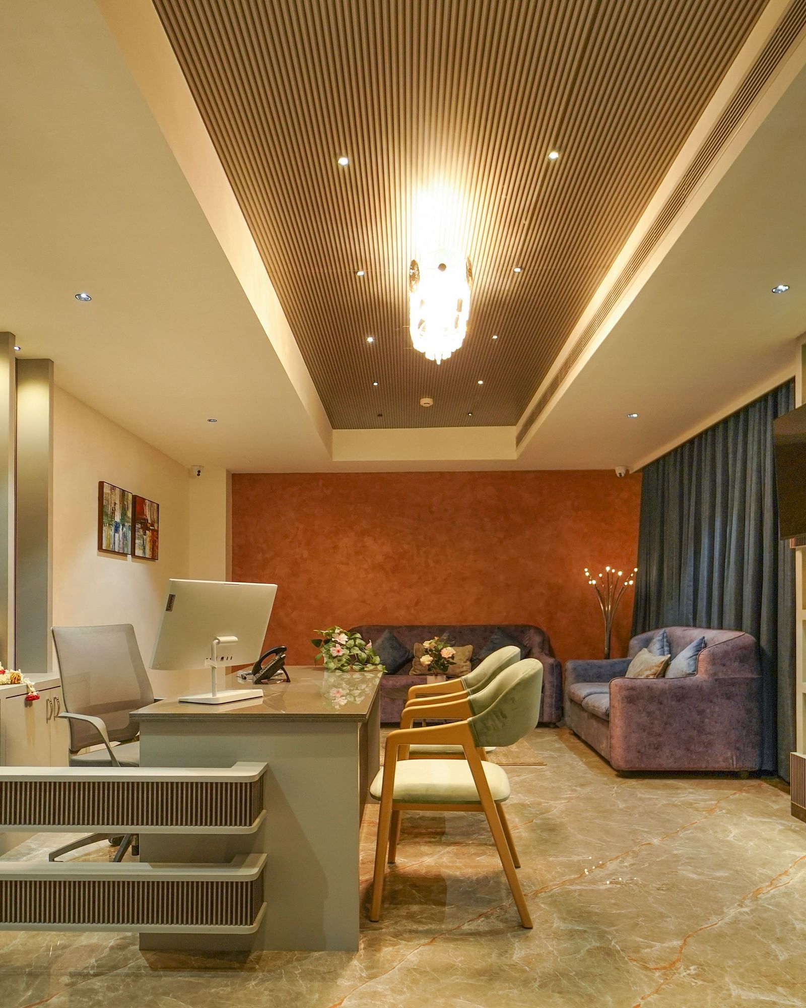 A hotel lobby area features a reception desk, seating arrangements with sofas and chairs, and decorative wall elements - Hotel Park Inn, Nellore.