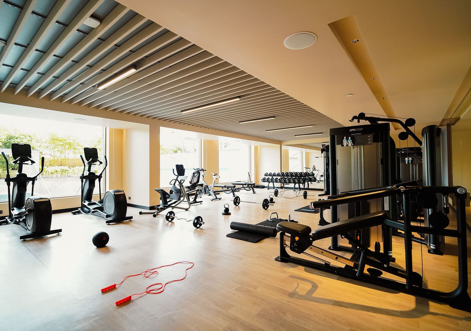 A Fitness Studio with equipment like treadmills, bench press table, and skipping rope - Grand Madurai by GRT Hotels