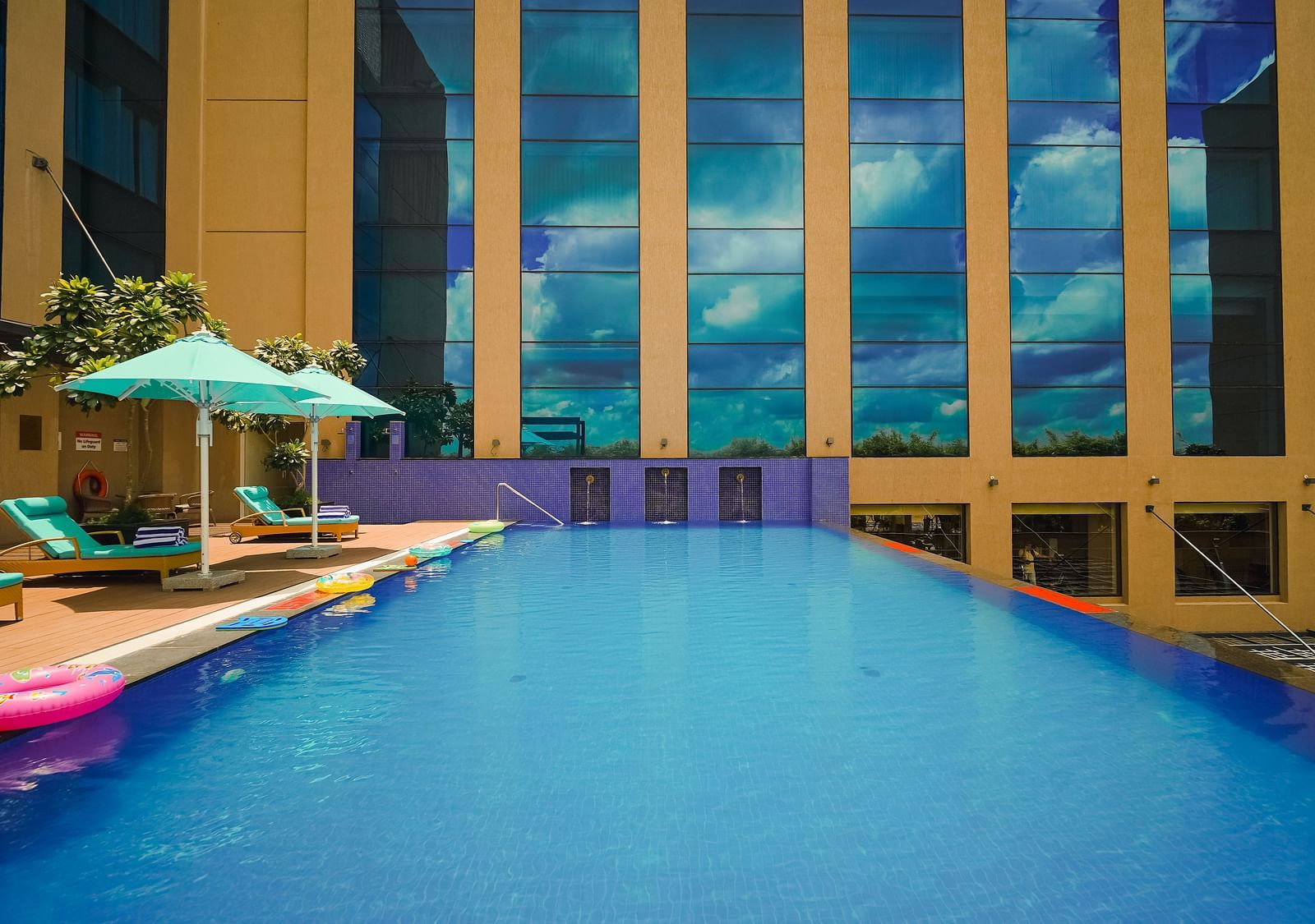 The poolside of our Madurai hotel featuring sun loungers for guests to relax on - Grand Madurai by GRT Hotels
