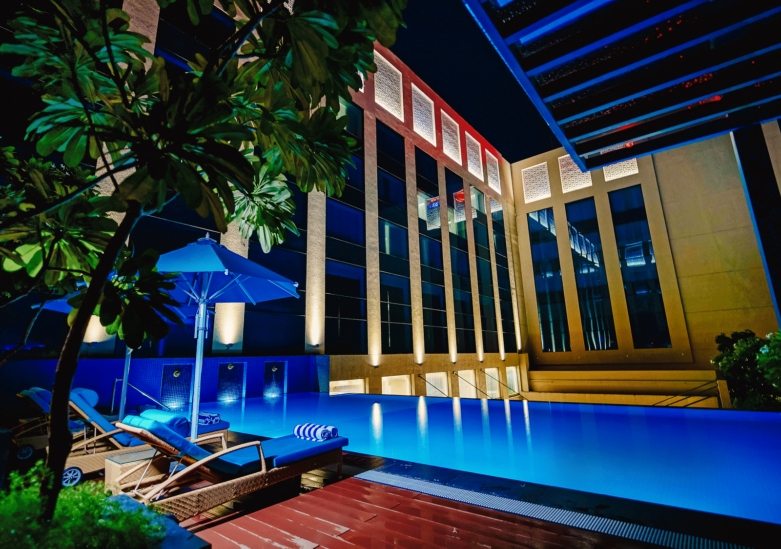 A luxurious pool area illuminated at night, offering a serene and relaxing atmosphere for guests - Grand Madurai by GRT Hotels