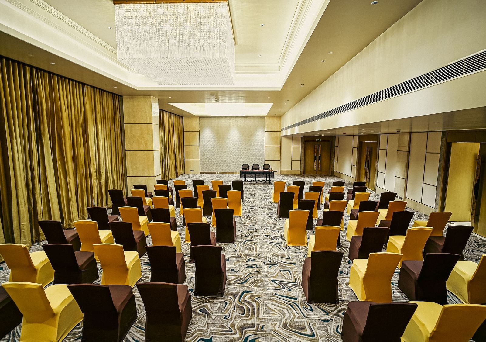 A modern conference room with a large table, executive chairs, and a presentation screen