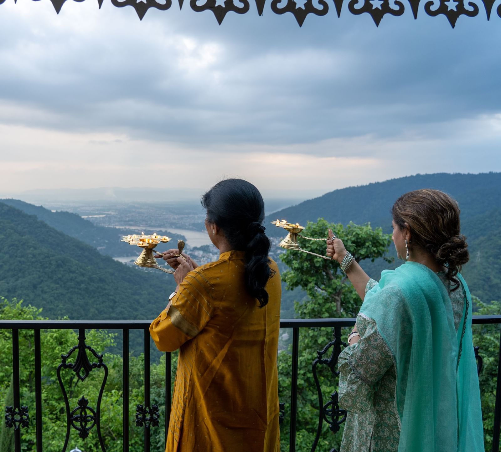 two women doing ganga aarti at Neer Ganga Resorts