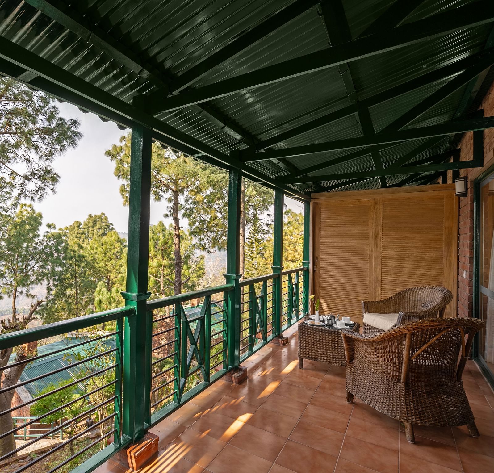 Premium Cottage sitting area with wooden chairs and beautiful greenery view - At baikunth Resort, Kasauli