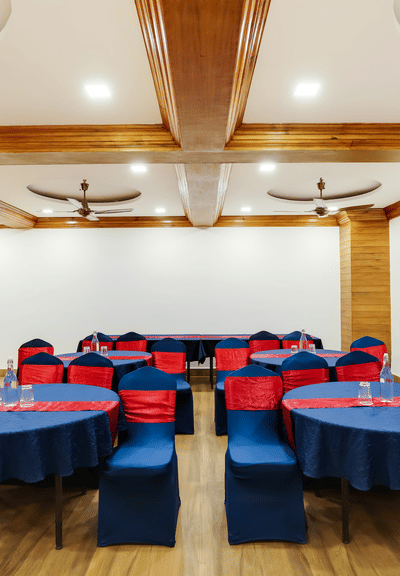 A close up shot of the banquet hall that features a seating arrangement with round blue tables and blue chairs.