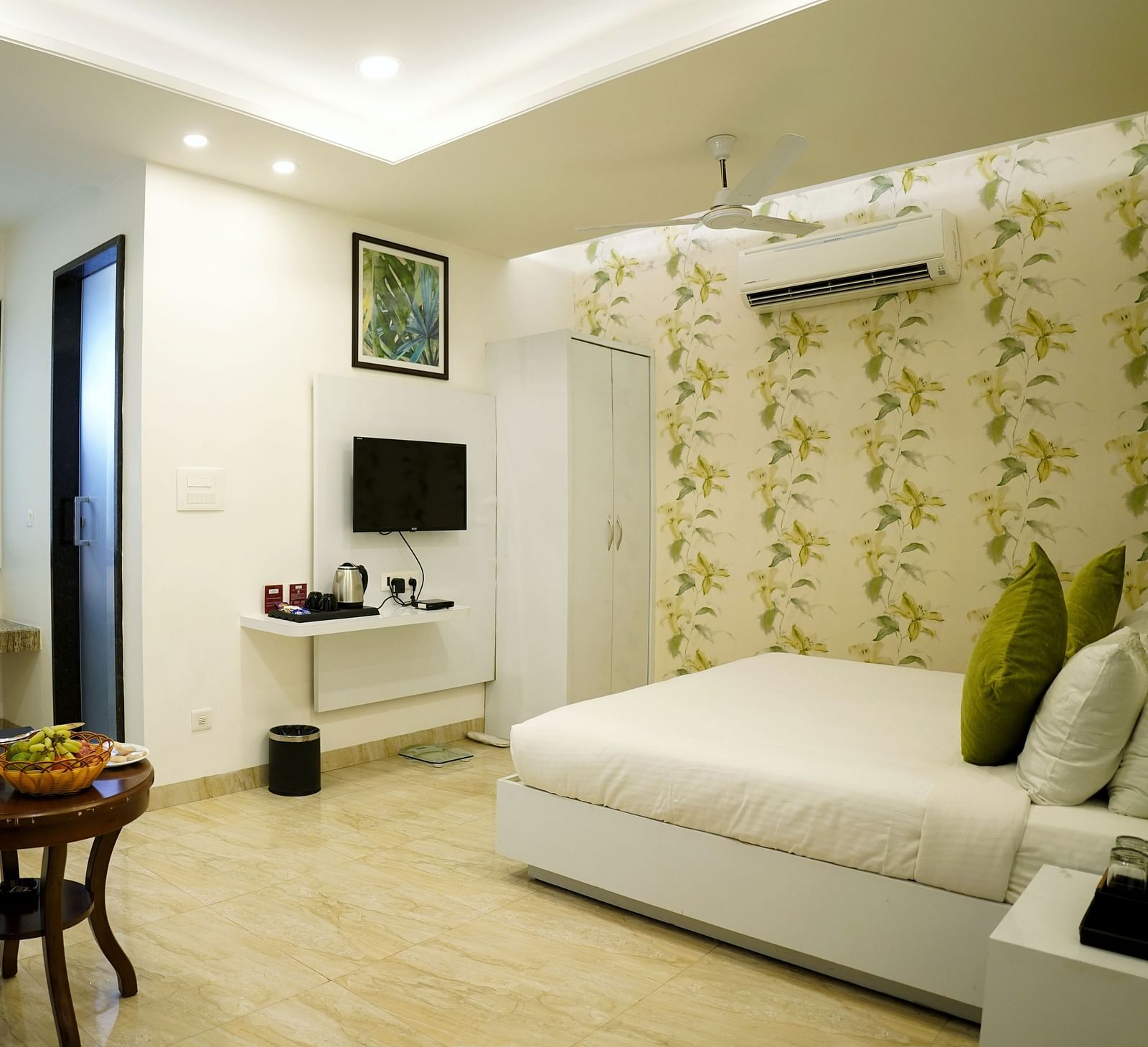A serene bedroom setup with a large window and a white and green colour scheme - TGI Insignia, Bhopal