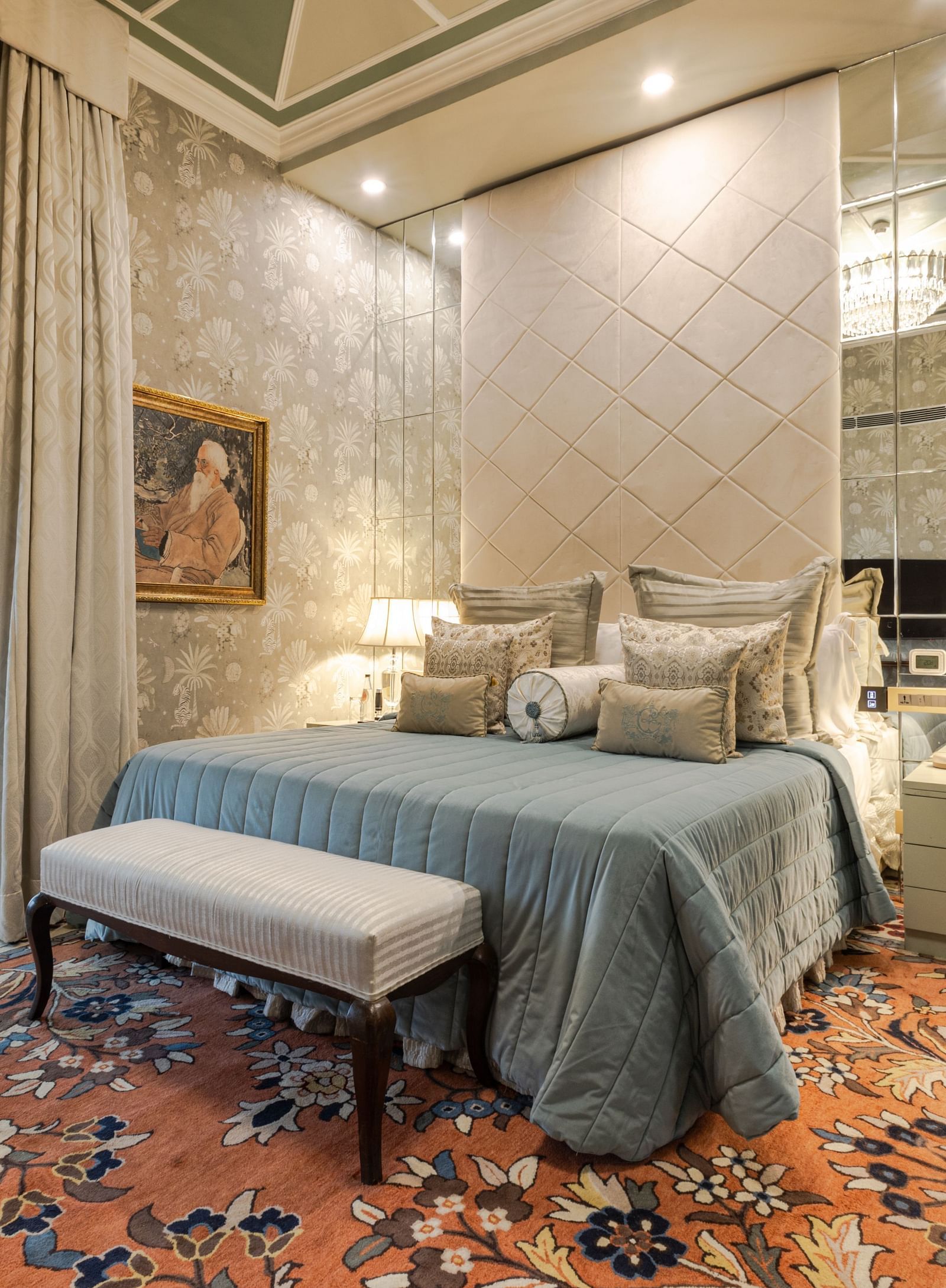 Luxury Suite with Whirlpool at The Claridges New Delhi, featuring a cosy bed with bedside lamps, a table at the foot of the bed, and a large window