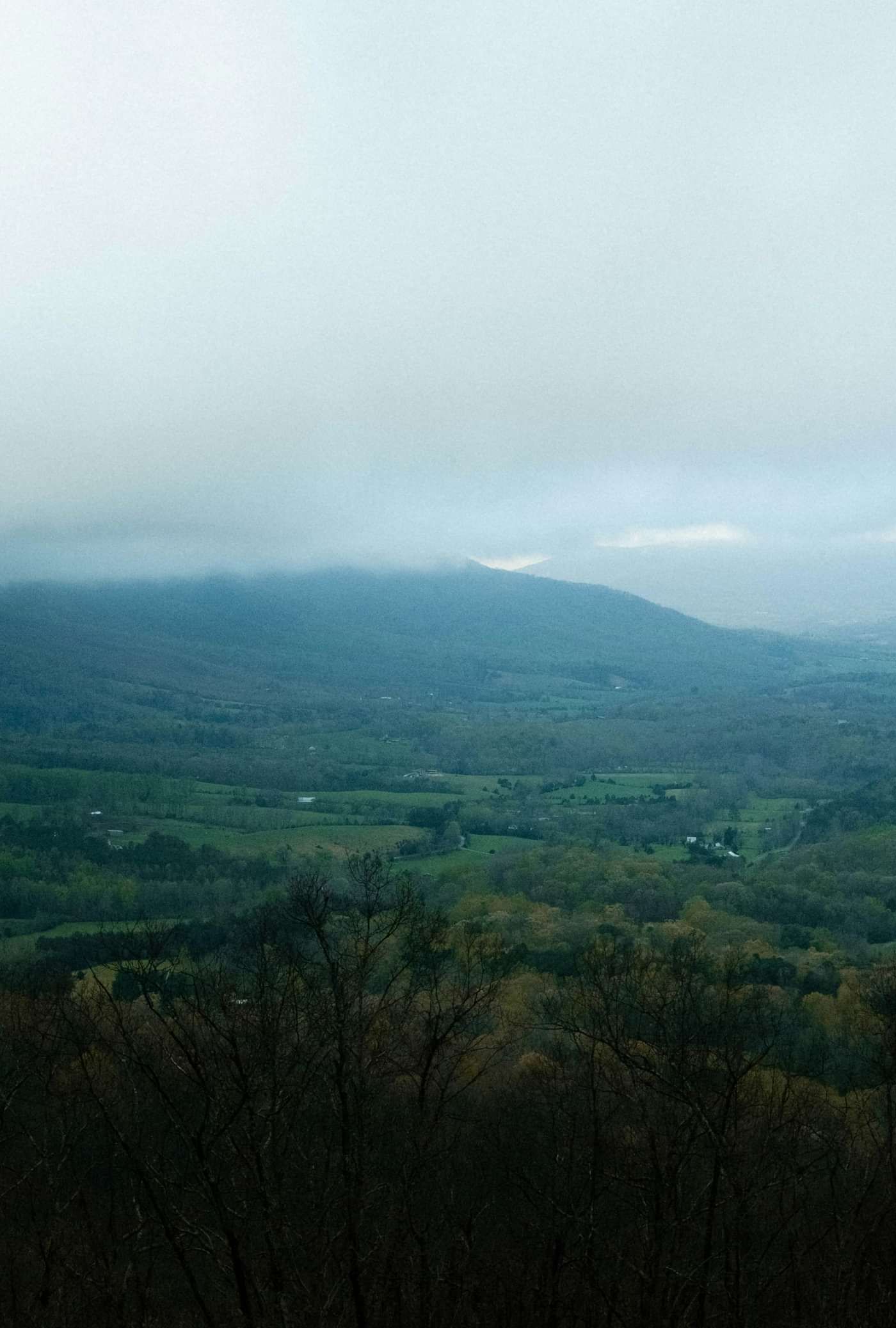 A scenic mountain landscape adorned with lush greenery, draped in drifting clouds, offering a breathtaking and tranquil view