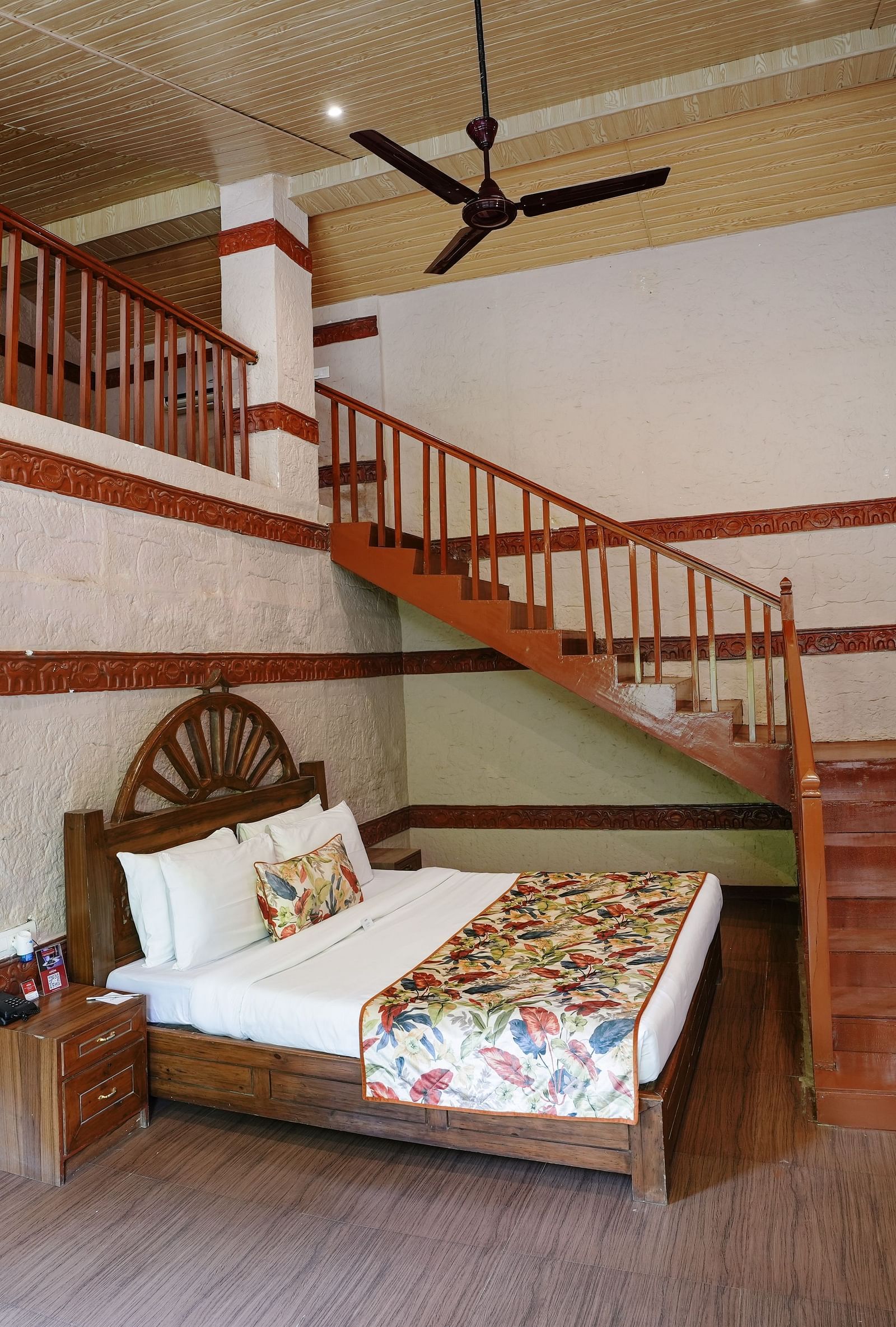 Duplex ethnic villa featuring a spacious bedroom and staircase leading to an additional room at Summit Green Lake Tea Resort & Spa, Kaziranga