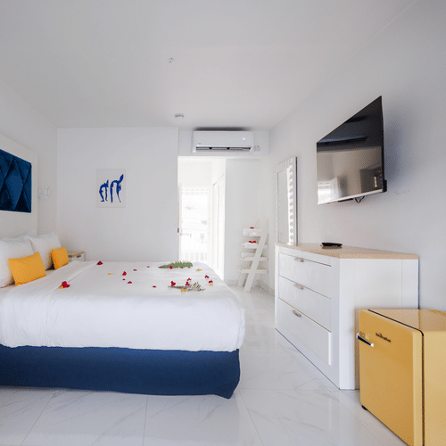 A bedroom featuring king size bed facing the T.V.  and wooden furniture at The Soco House.