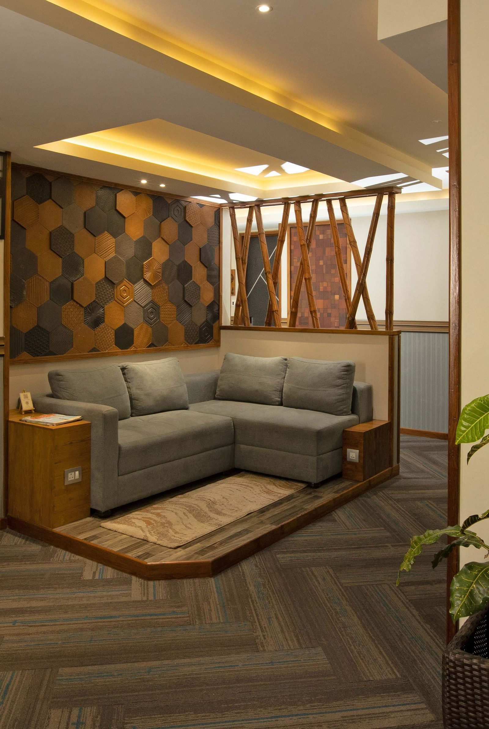 Image of the lobby area at Coral Reef Hotel and Spa in Port Blair featuring a seating space with L shape sofa and wall hangings and plant 