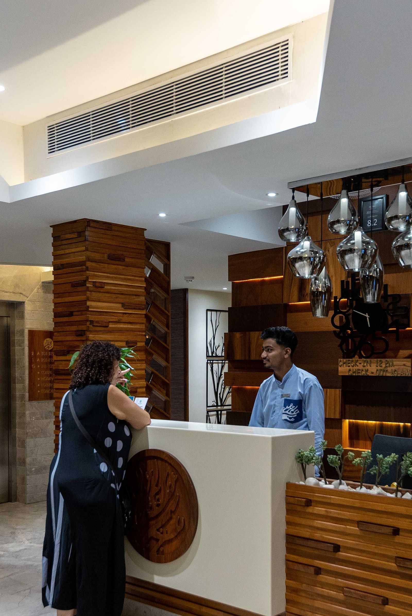 Image of a receptionist at Coral Reef Hotel and Spa in Port Blair communicating with a customer at the reception desk