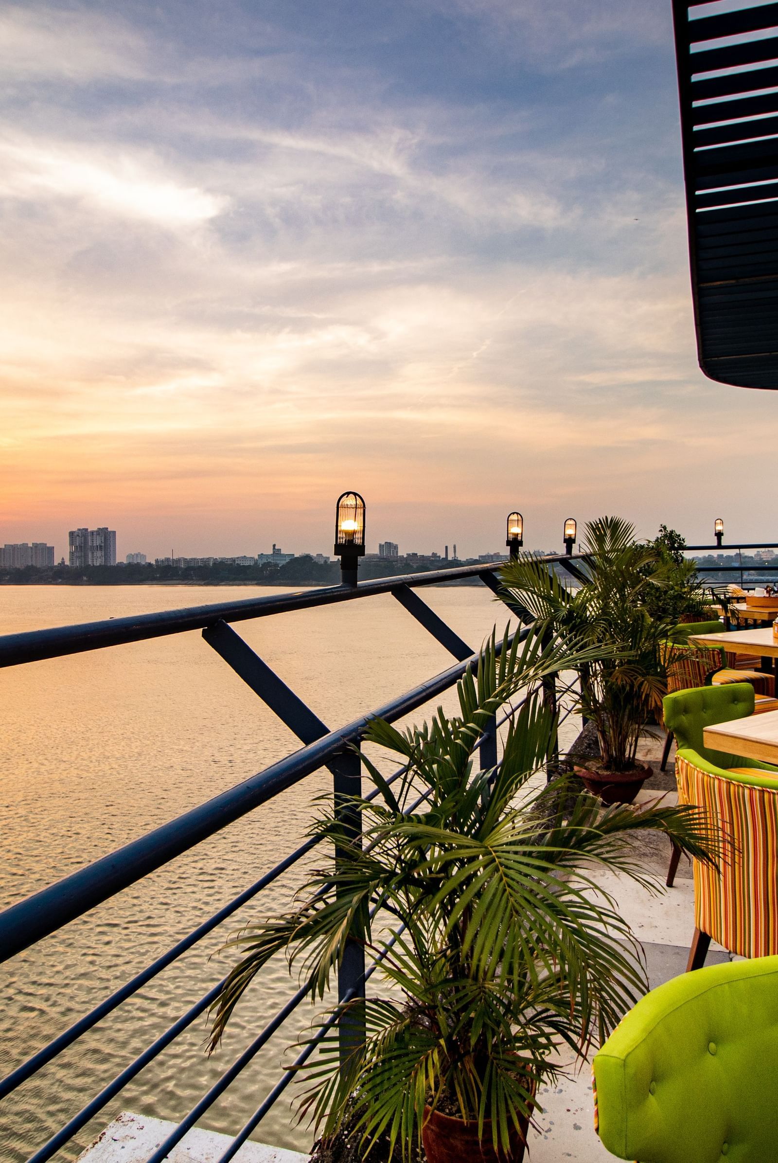 An elegant outdoor dining seating area at Polo Floatel Kolkata with a view of the river. 