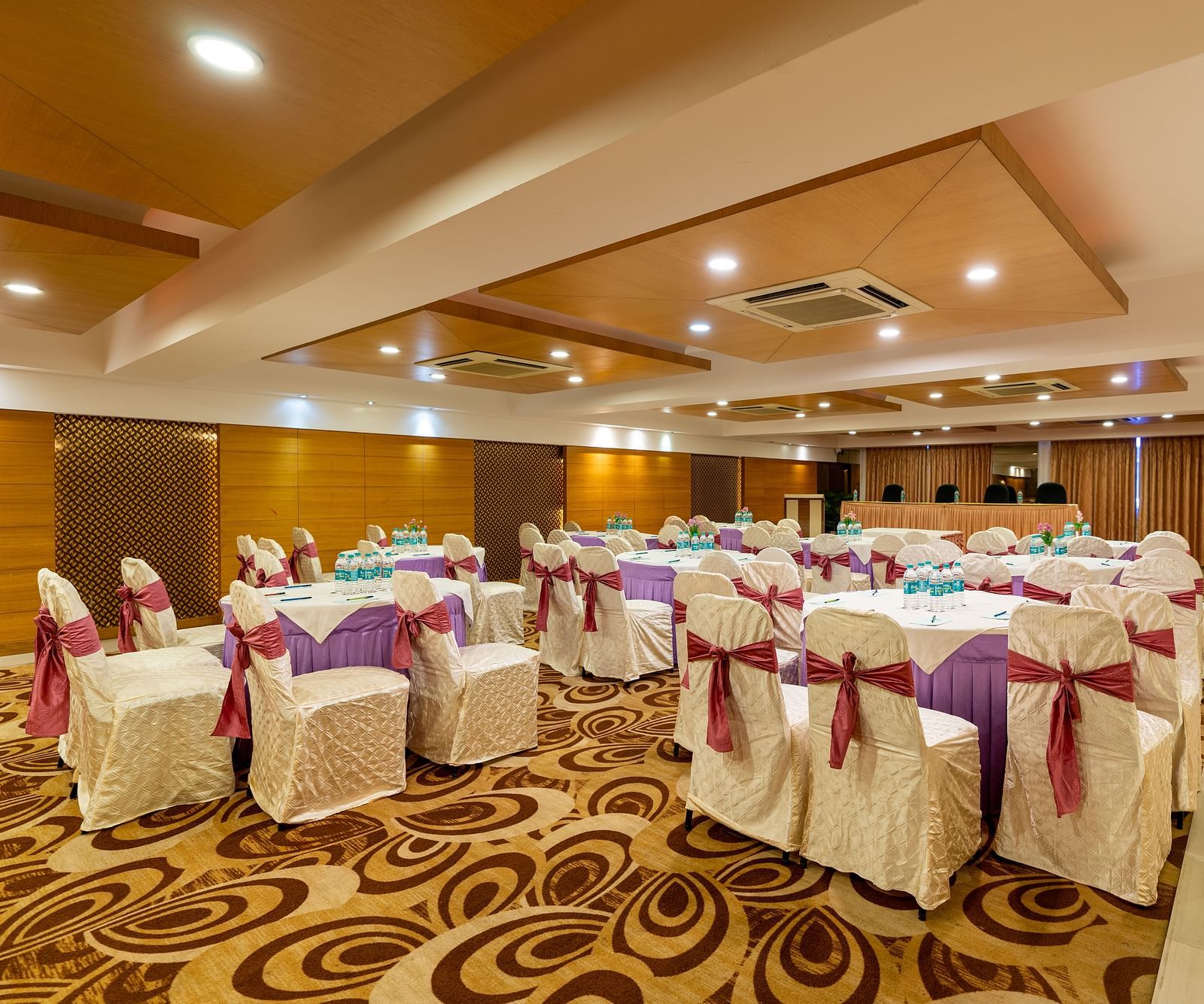 round table seating inside the banquet hall during an event - Hotel Pai Vista, Mysore