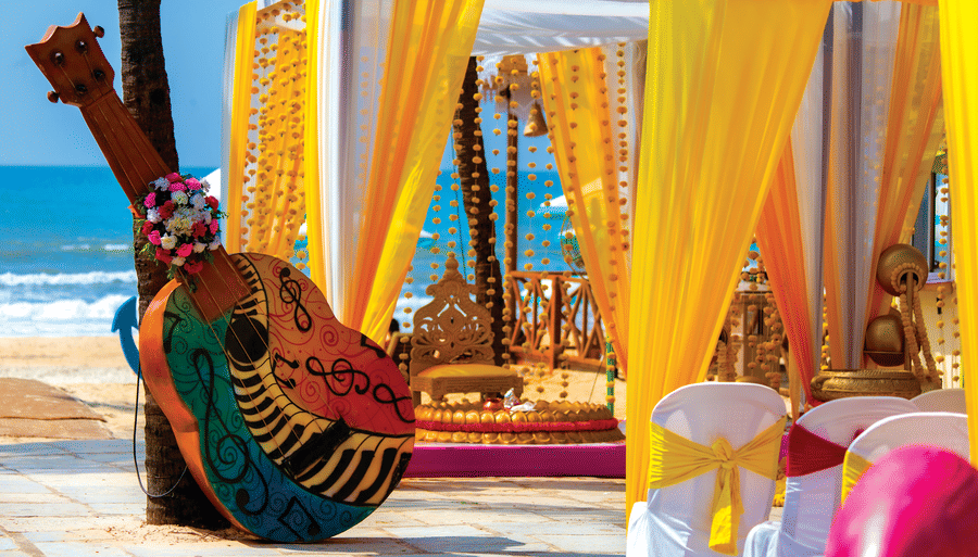 a decorated cabana with a guitar leaning on a tree - Caravela Beach Resort Goa