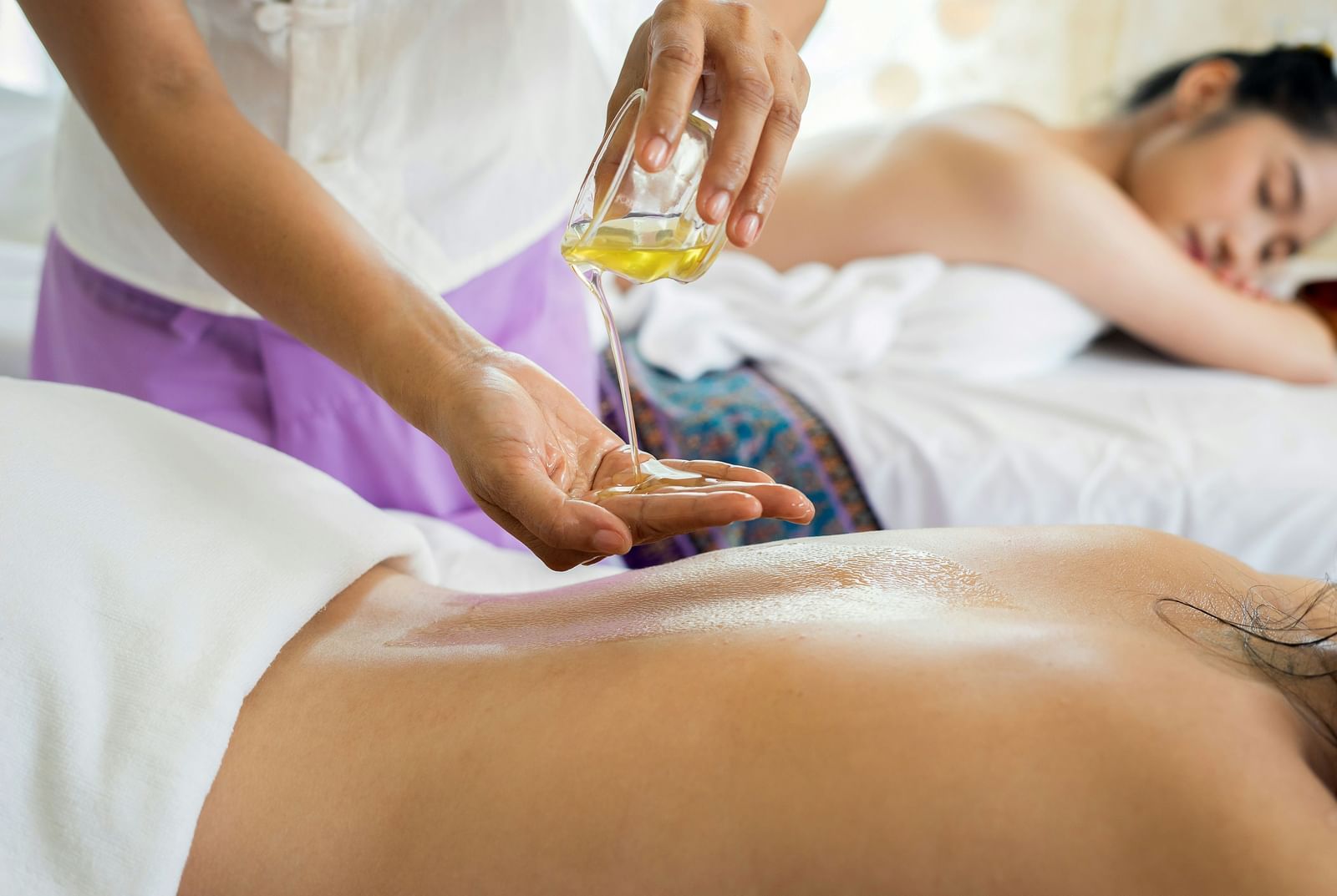 Therapist performing a relaxing oil massage on a guest