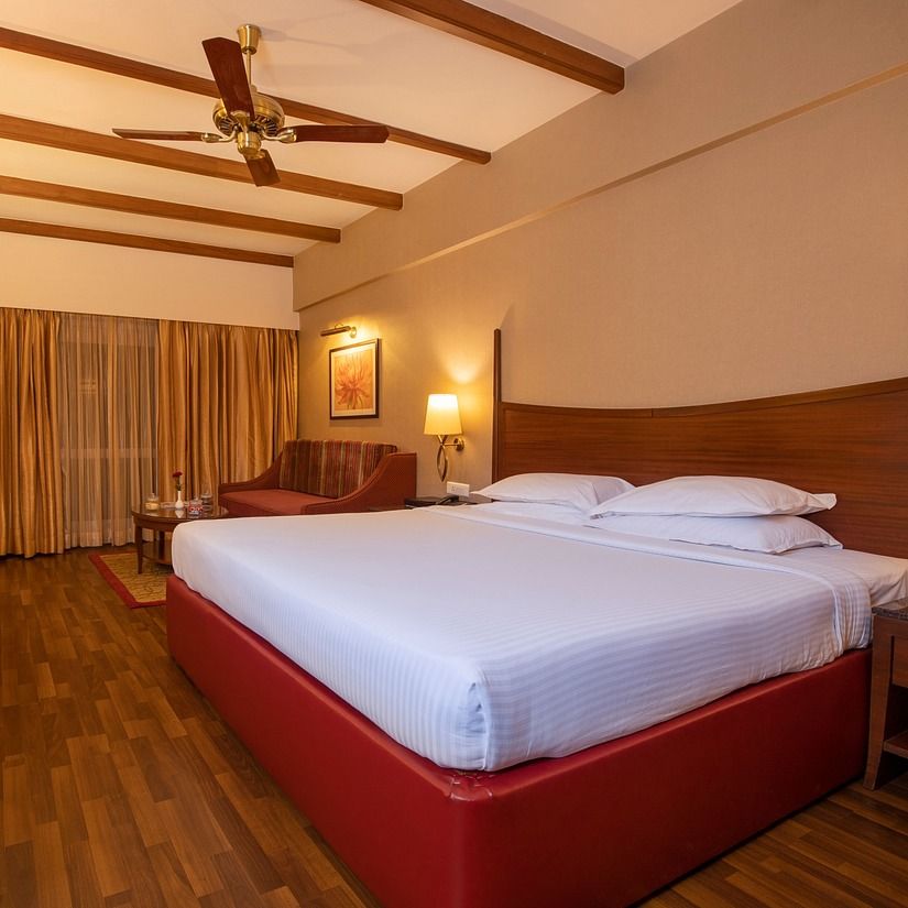 An image of a bedroom at The Carlton featuring a bed, a flat TV screen, etc 