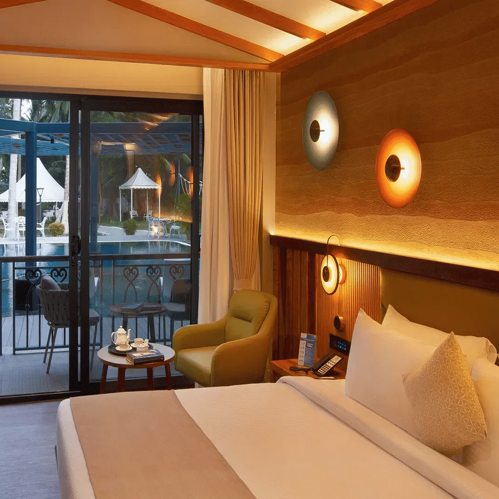 Coral Sapphire at Coral Reef Resort and Spa in Havelock featuring a plush bed and a seating space next to it with the door to the outdoor lounge area beside it  