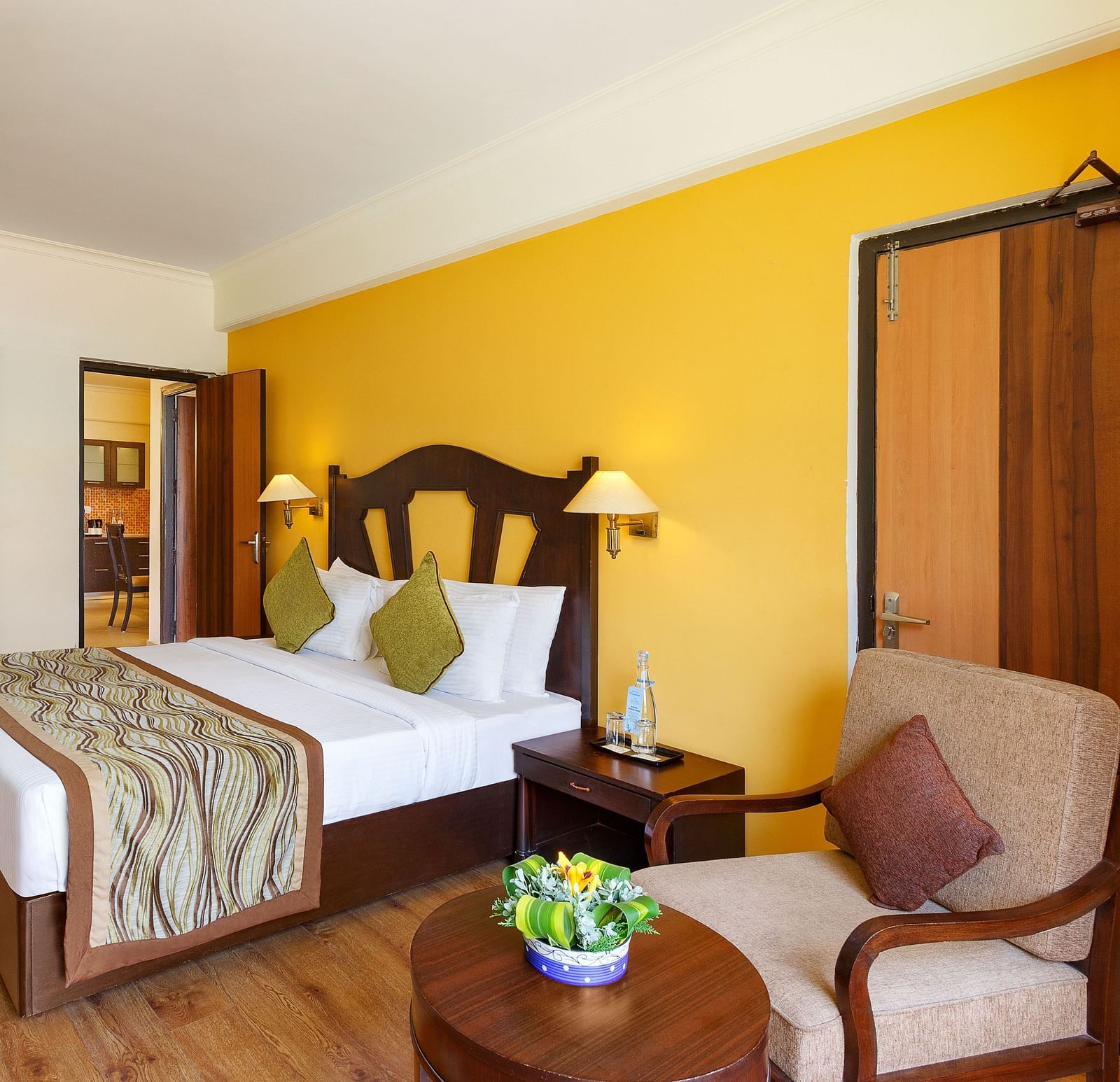 This image showcases a luxurious hotel room of aloha on the ganges, with a warm and inviting atmosphere. The room features a large king-size bed with a plush headboard and comfortable bedding.