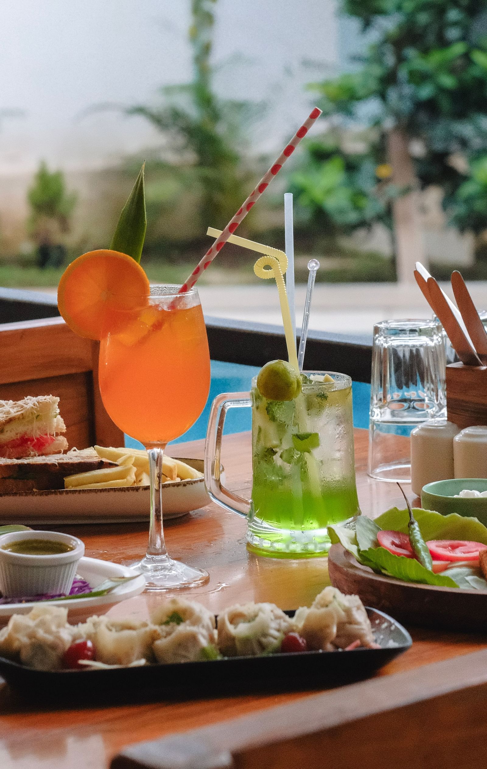 A tropical-style breakfast spread with fresh juice, salads, and continental dishes on a patio table – The Verda de Miranda Resort.