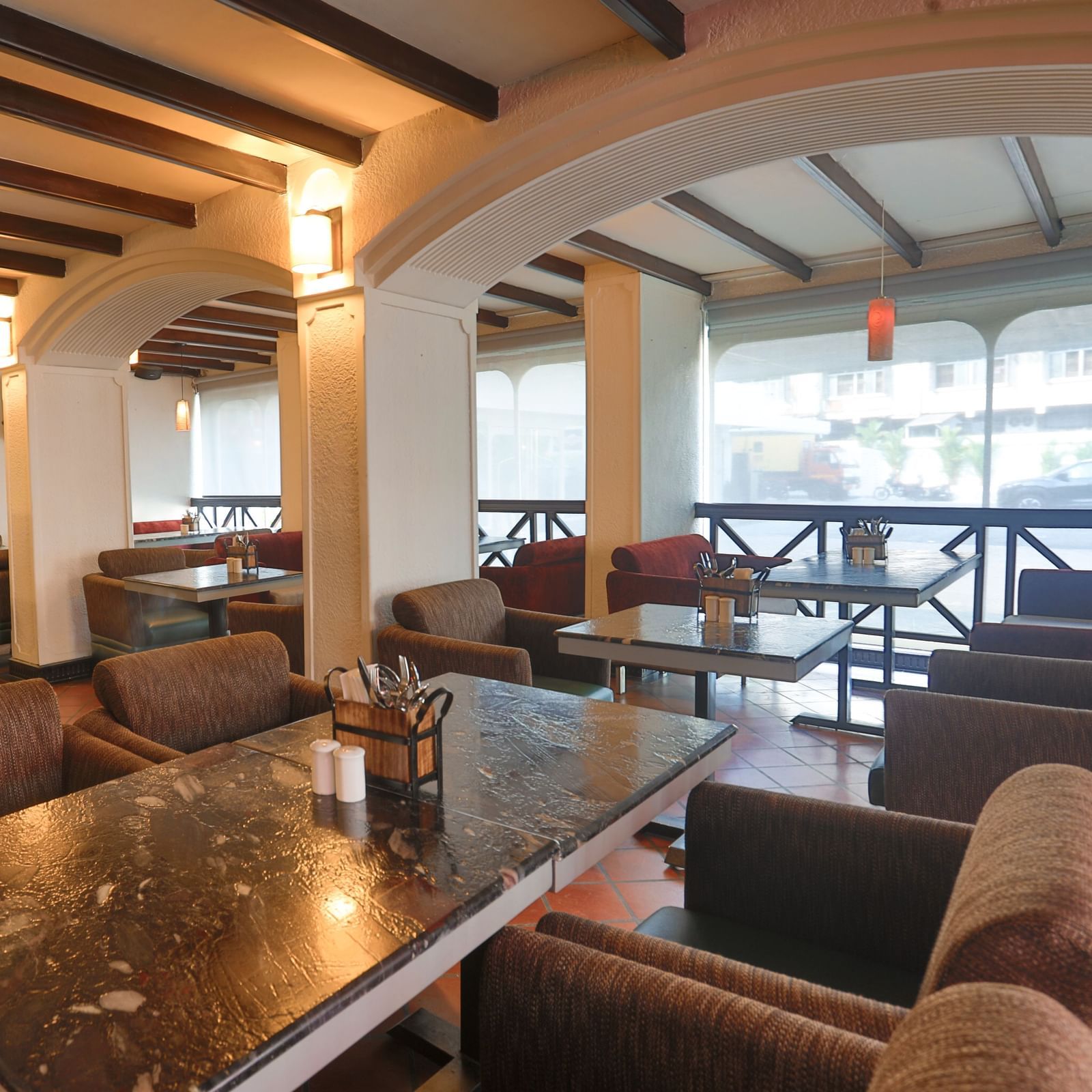 An inviting restaurant interior at Shilton International, Kochi, features a mix of dining tables and lounge seating, with a bar area.