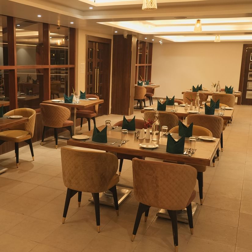 An image of a restaurant with several chairs and dining tables at Mastiff Grand, Dharwad
