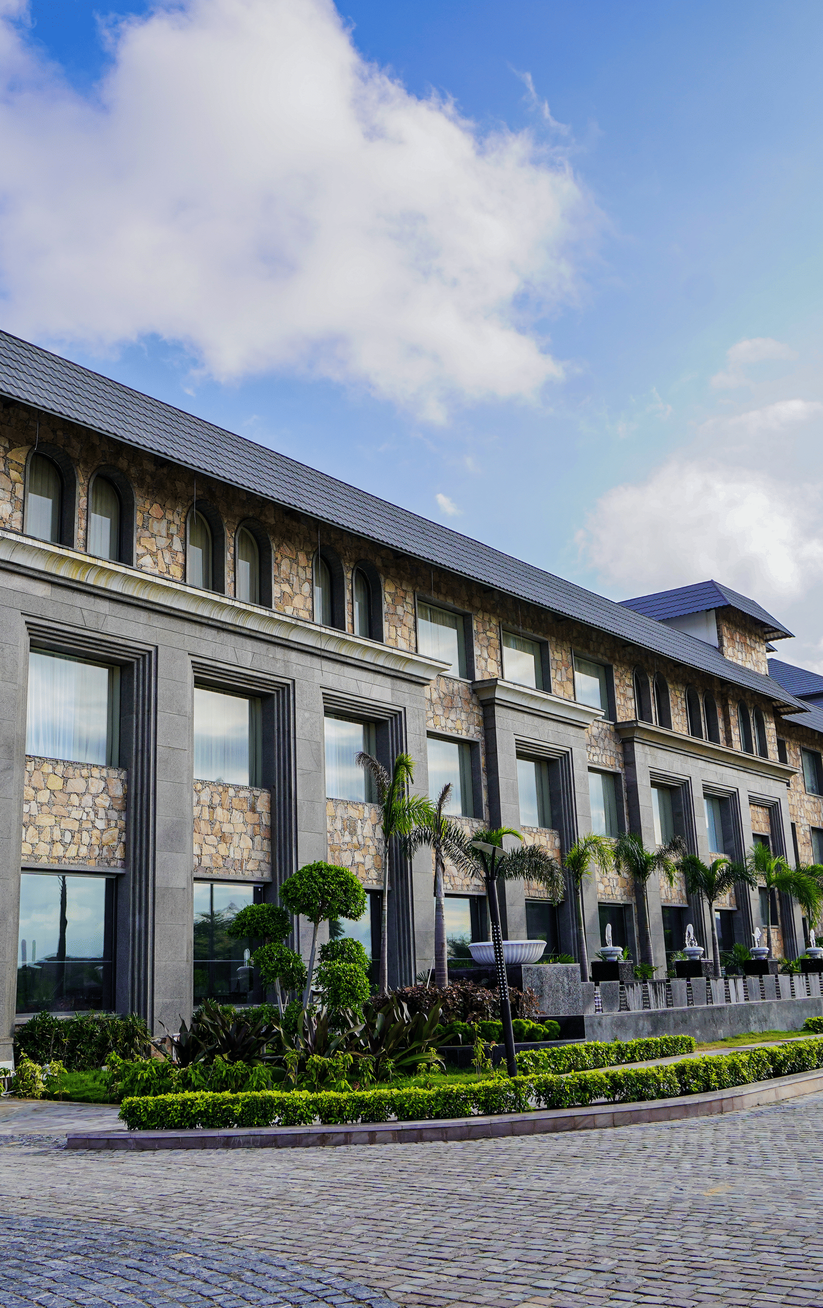 A low-angle shot of a multi-storey stone and glass building, which is the main part of the resort.