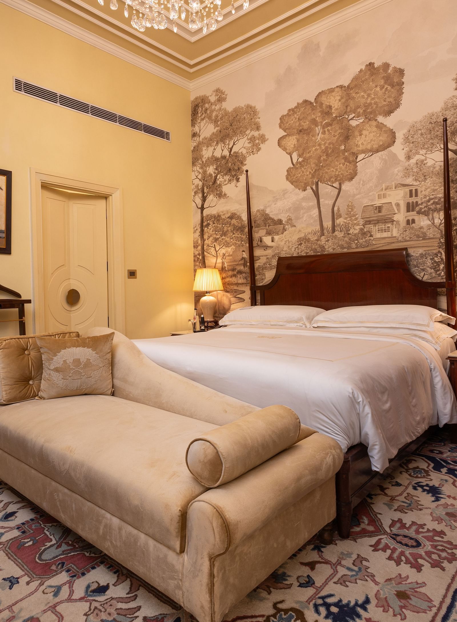 image of a bedroom at our heritage room with a brown scale wallpaper with lush trees - The Claridges New Delhi 