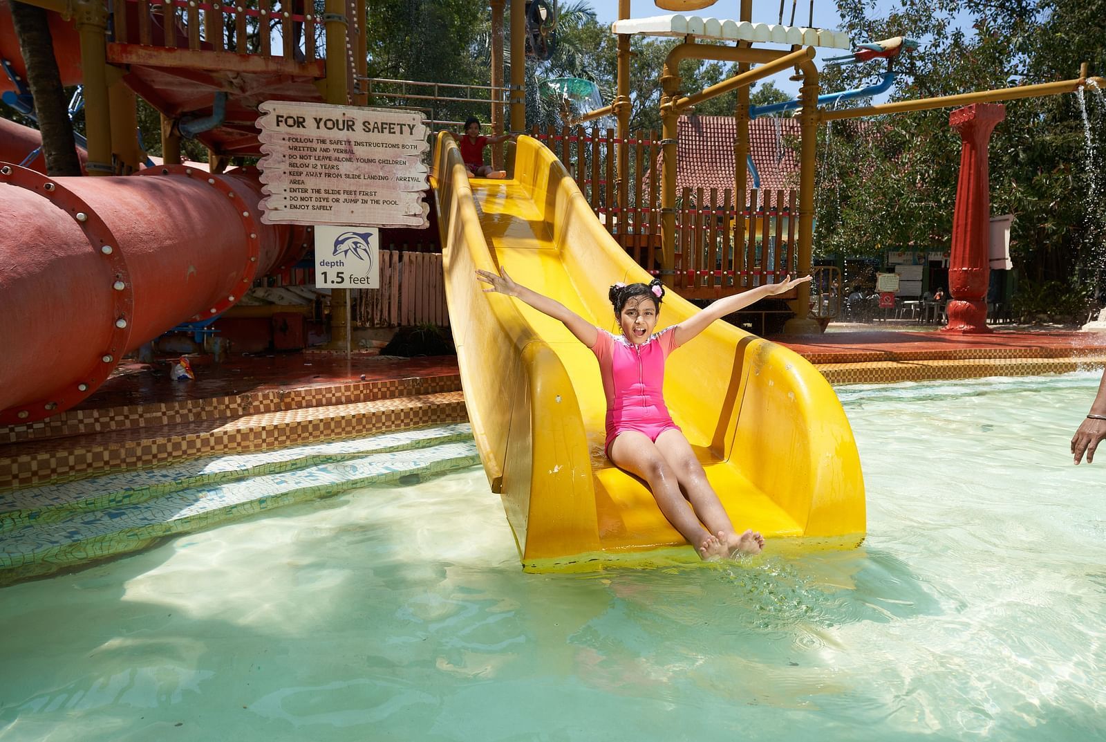 An image of the Zoomroo Slide at Water Kingdom where a girl is sliding down into the water