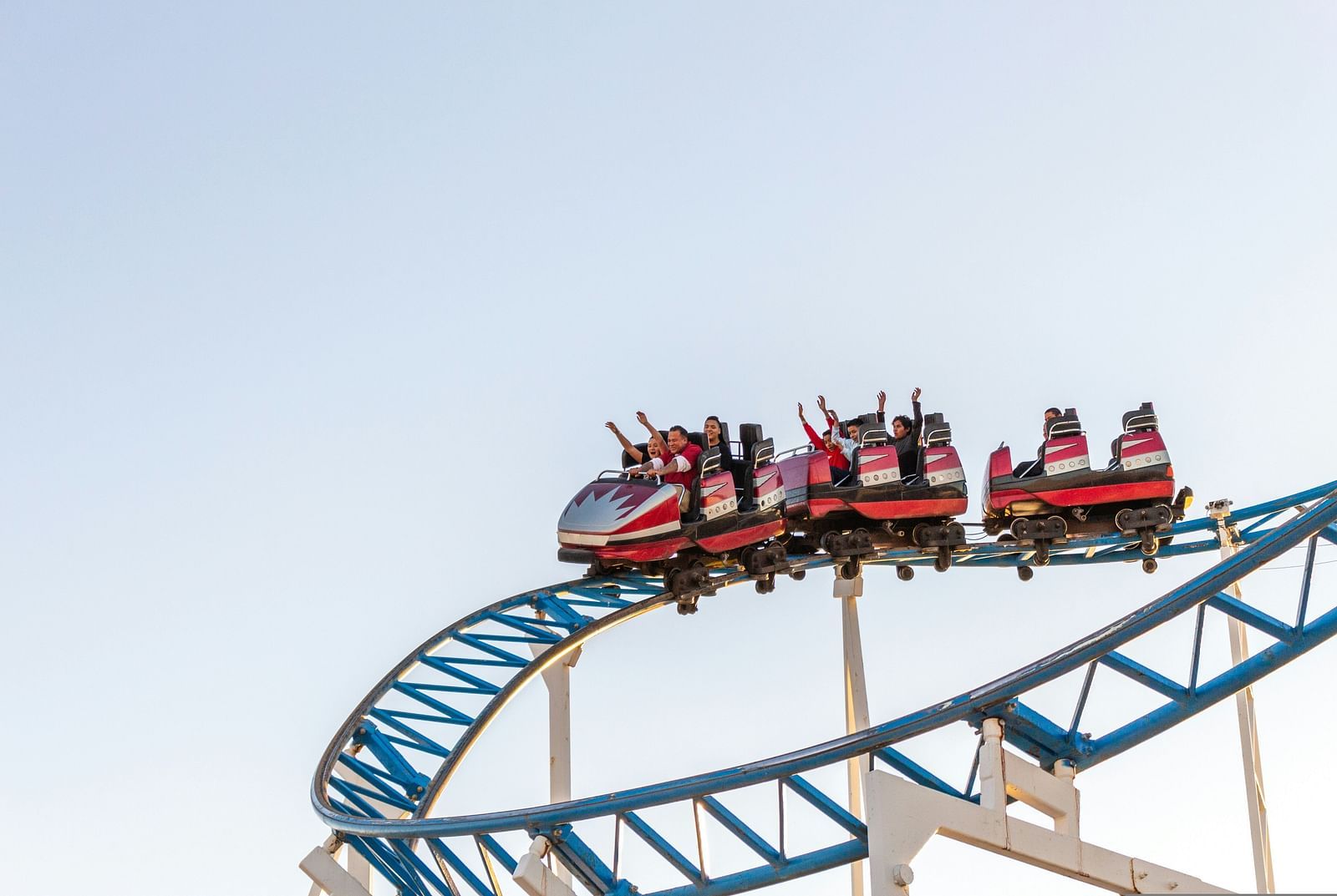 a group of people sitting inside cars during a roller coaster ride with the image showing them enjoying the ride