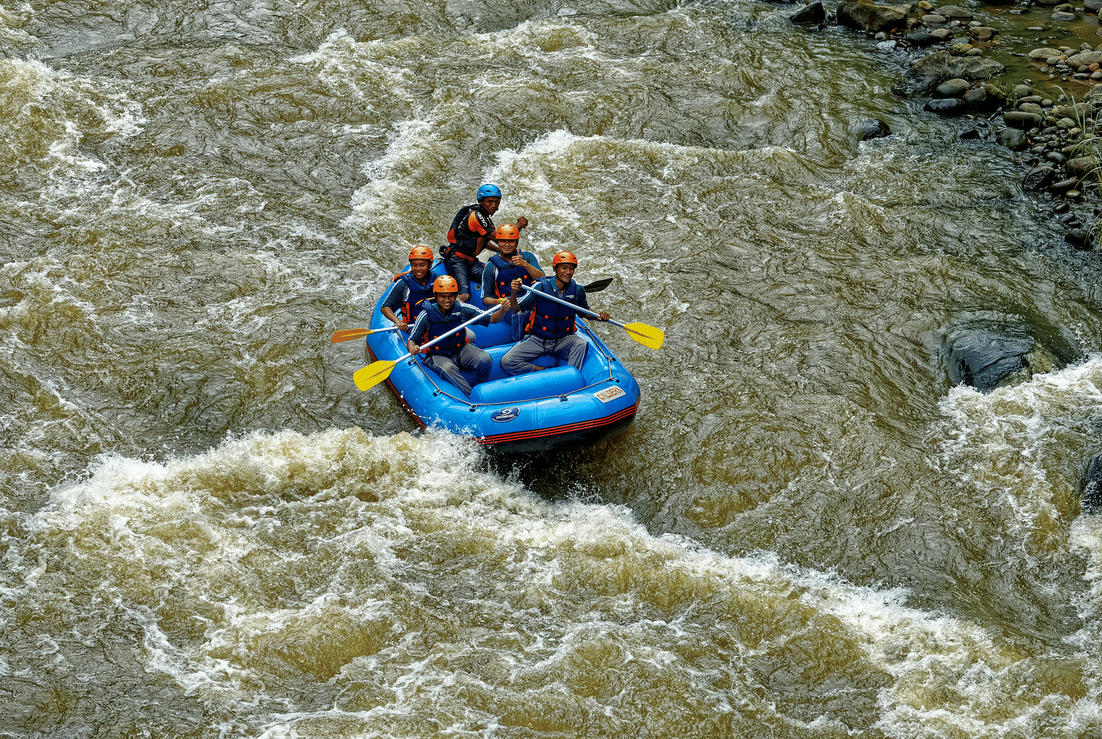 A small group of people engaged in river rafting, relishing the thrill of the adventure