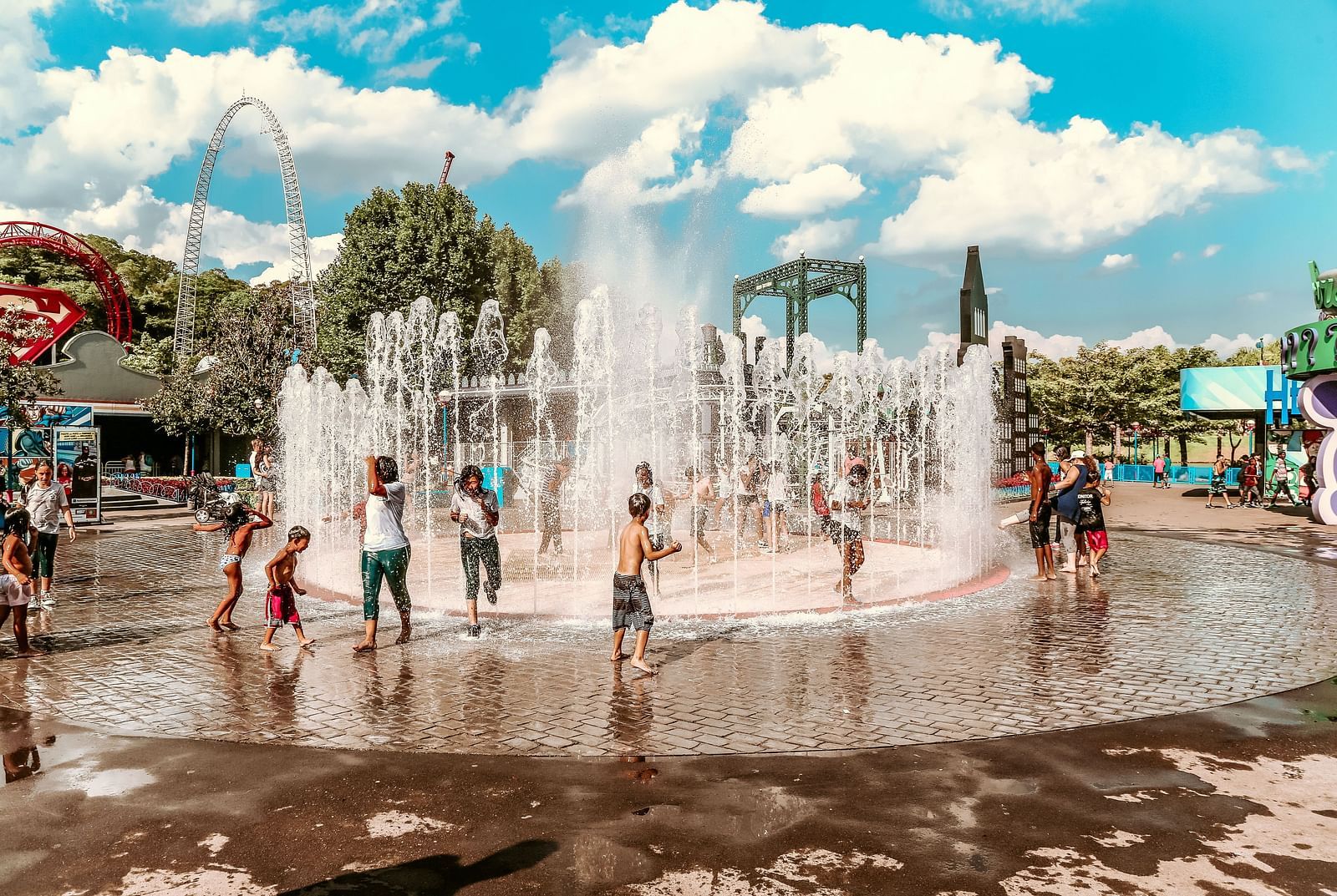 People palying around a water fountain in a water park