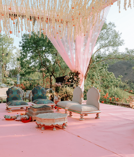 Wedding mandap decorated with pink drapes, floral arrangements, and seating overlooking the surrounding landscape at one of the best resorts near Udaipur | YAAN Udaipur