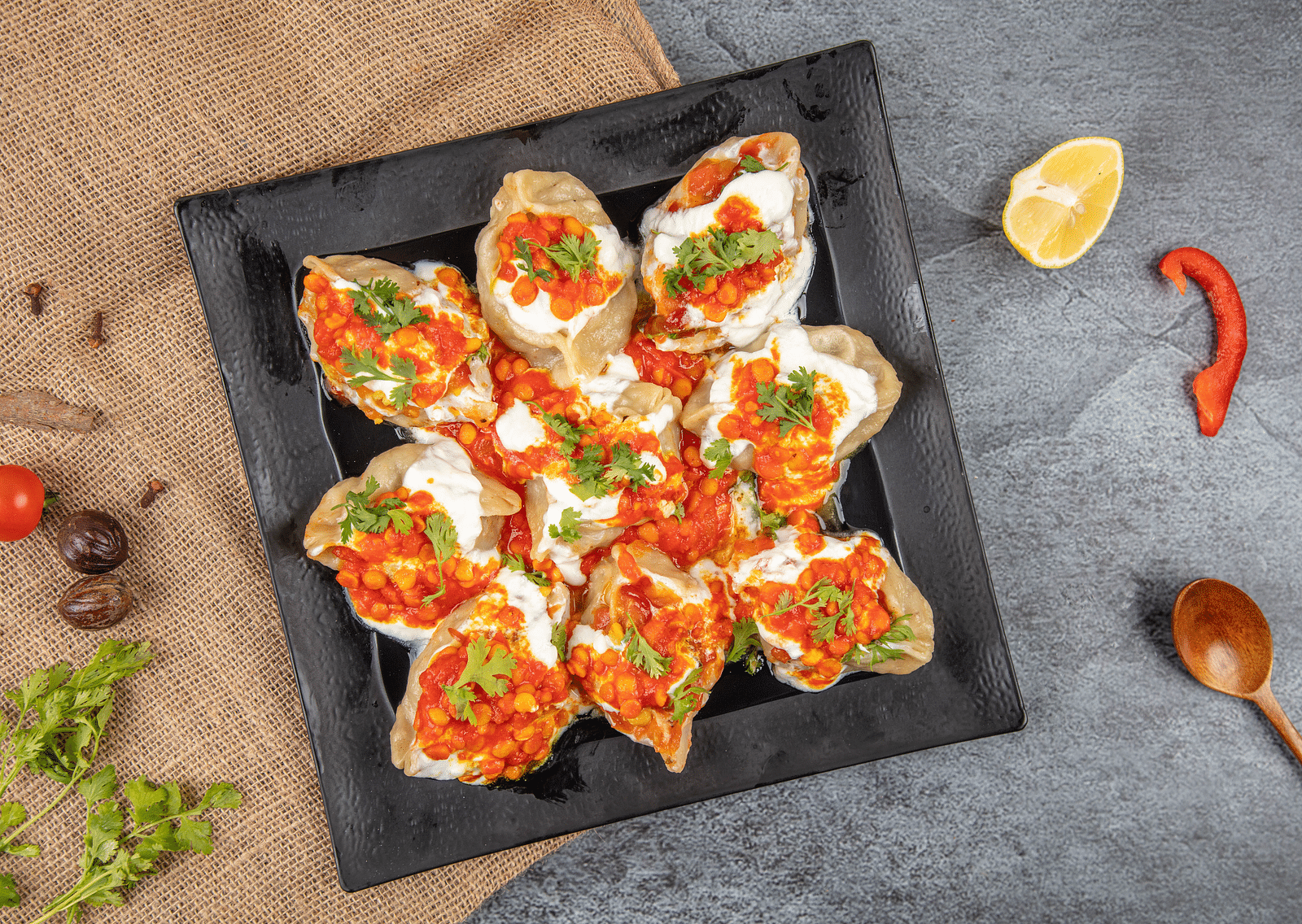 An aerial view of a chaat preparation with curd that is kept on a plate.