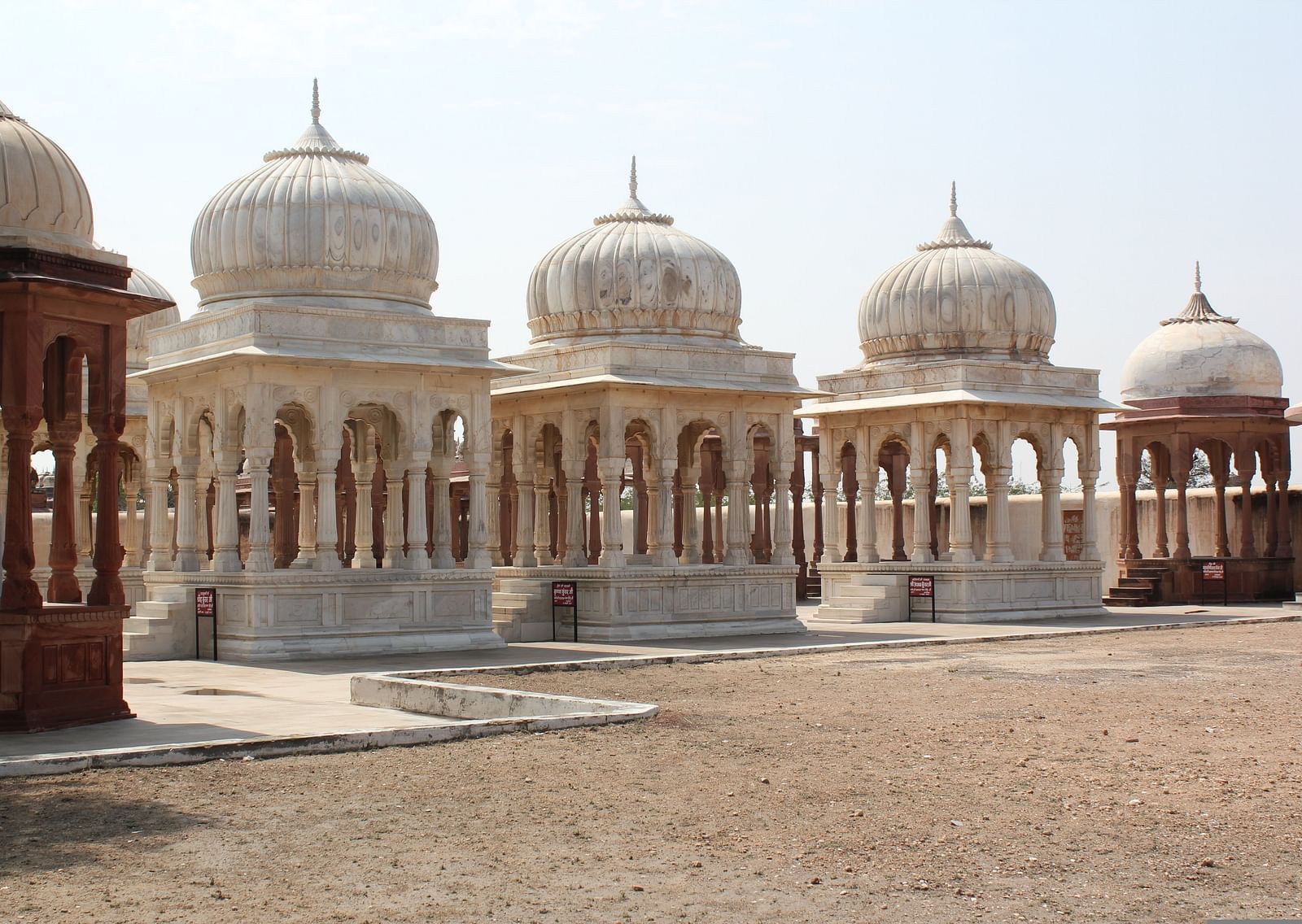 An overview of numerous cenotaphs made of white marble with blue sky in the background.