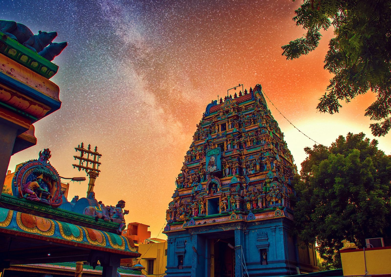 An overview of a temple in Chennai with the sun setting in the background.